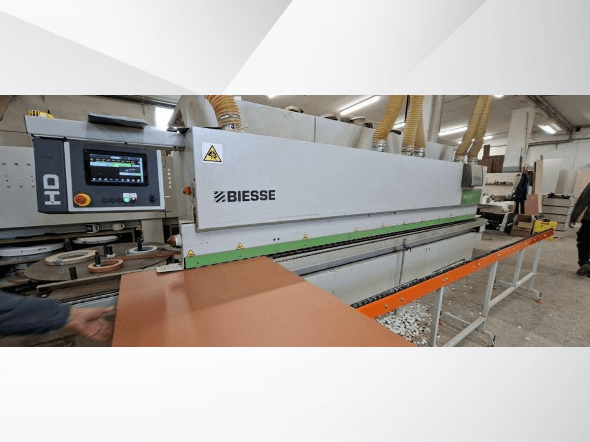 BIESSE JADE 340 malu līmēšanas mašīna darbnīcā, skats no priekšpuses ar digitālo vadības paneli un oranžu padeves galdu.
