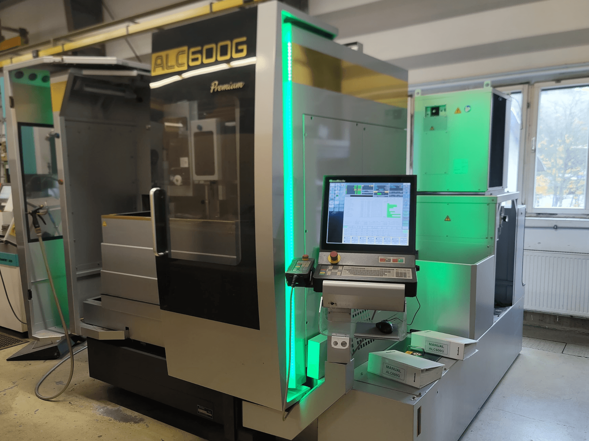 Sodick ALC600G Premium stiepļu EDM mašīna, priekšējais skats, redzams vadības panelis un izgaismotas ārējās detaļas.