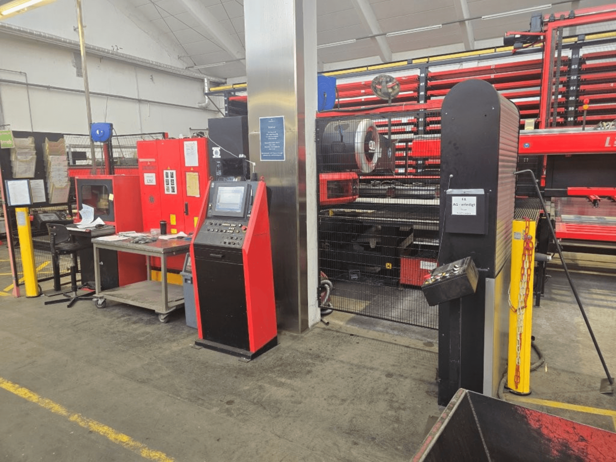 AMADA EMZ 3610 NT CNC perforācijas mašīnas priekšskats, kurā redzamas operatora vadības ierīces un drošības apvalks rūpnīcas vidē.