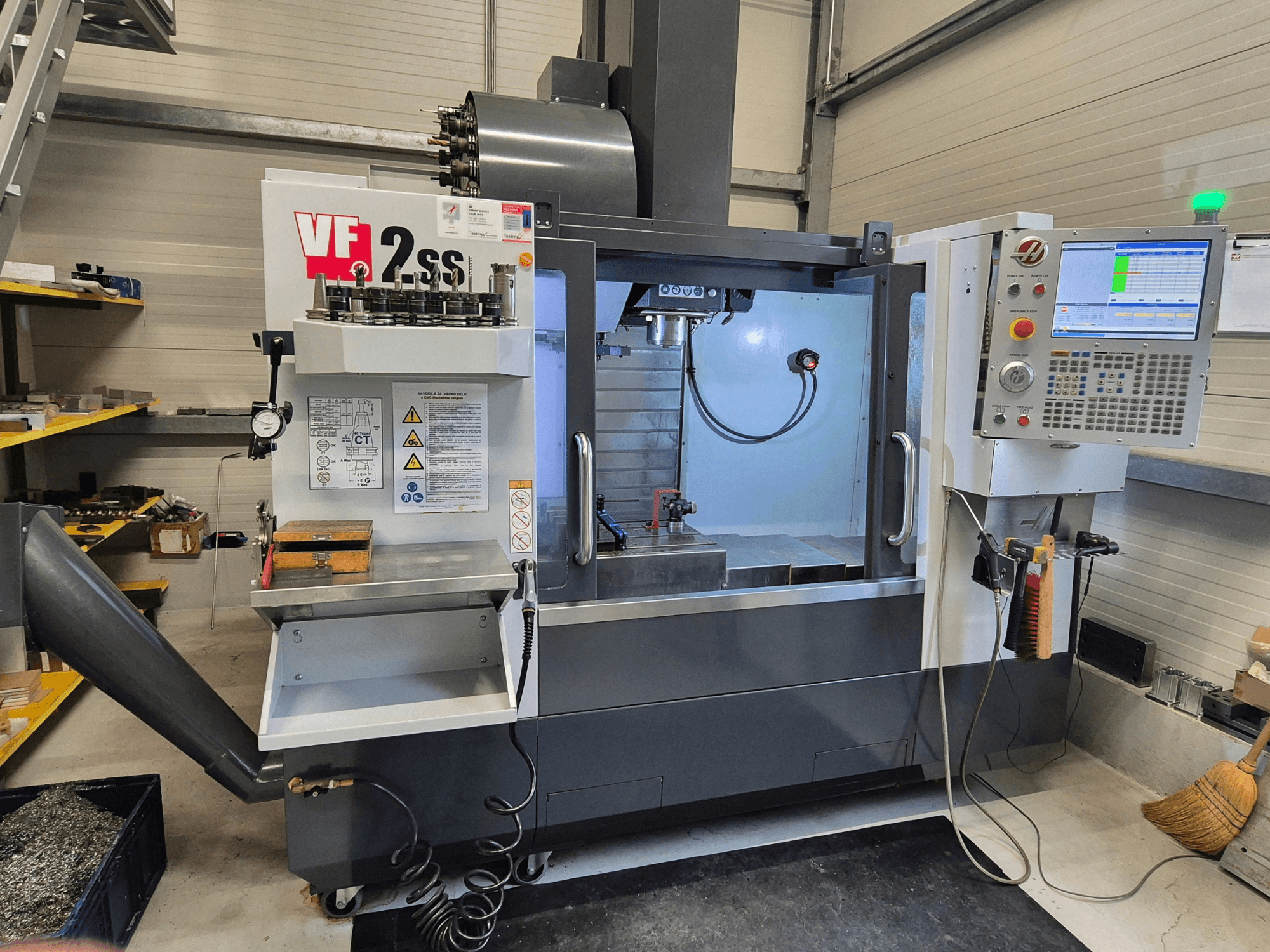 HAAS VF2 SS-EU vertikālais apstrādes centrs no priekšpuses, kurā redzamas vadības ierīces, vārpsta un apstrādes zona.