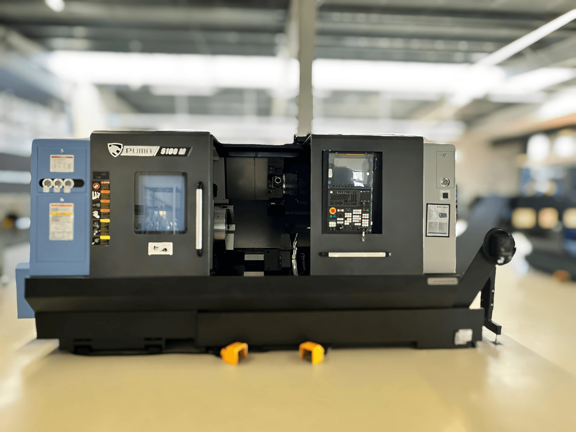 DN SOLUTIONS PUMA 5100 MB Turn-Mill centra priekšējais skats, kurā redzams vadības panelis un apstrādes zona.