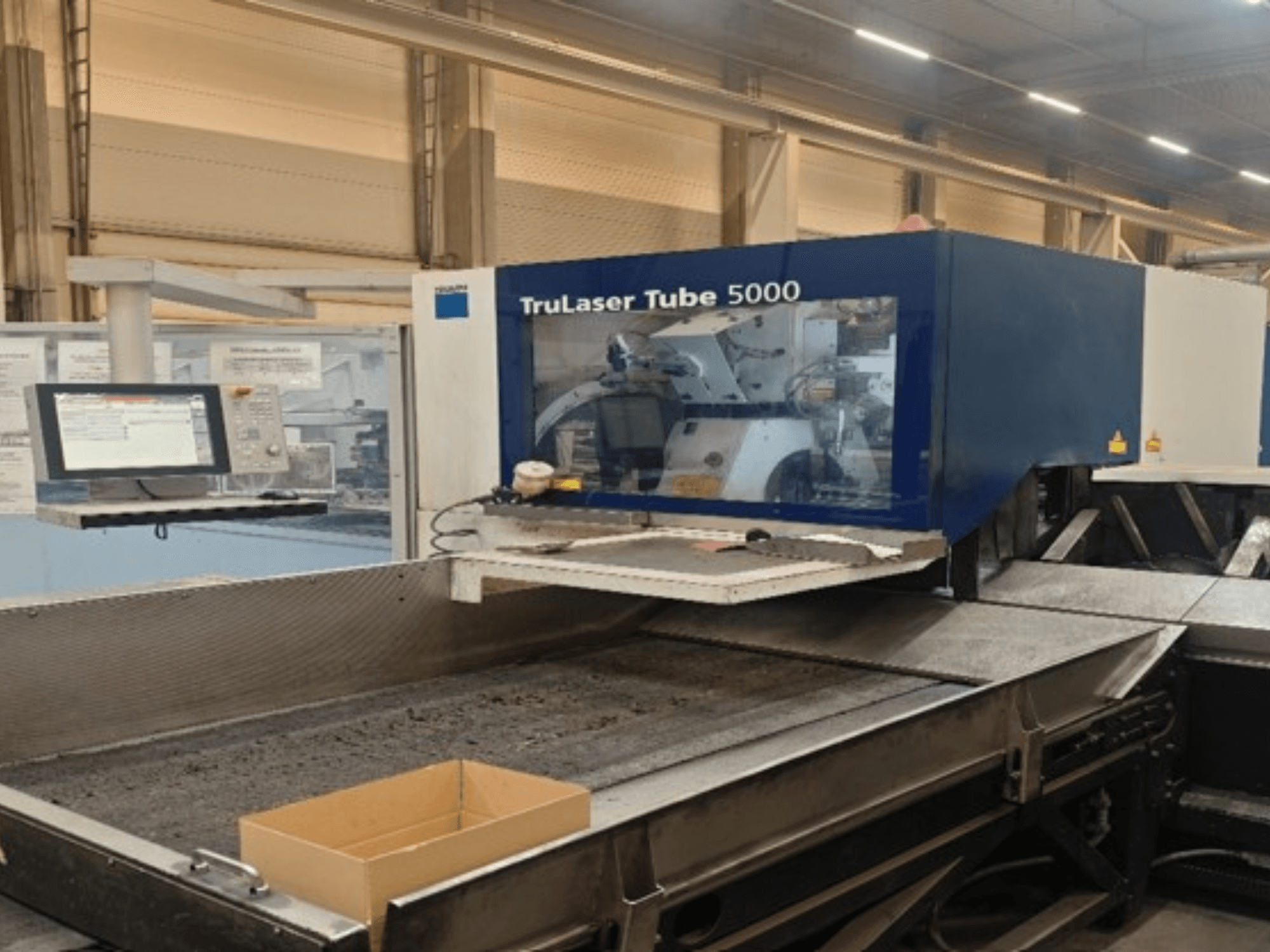 TRUMPF TruLaser Tube 5000 skats no priekšpuses, kurā redzams vadības panelis un griešanas zona precīzai cauruļu griešanai.