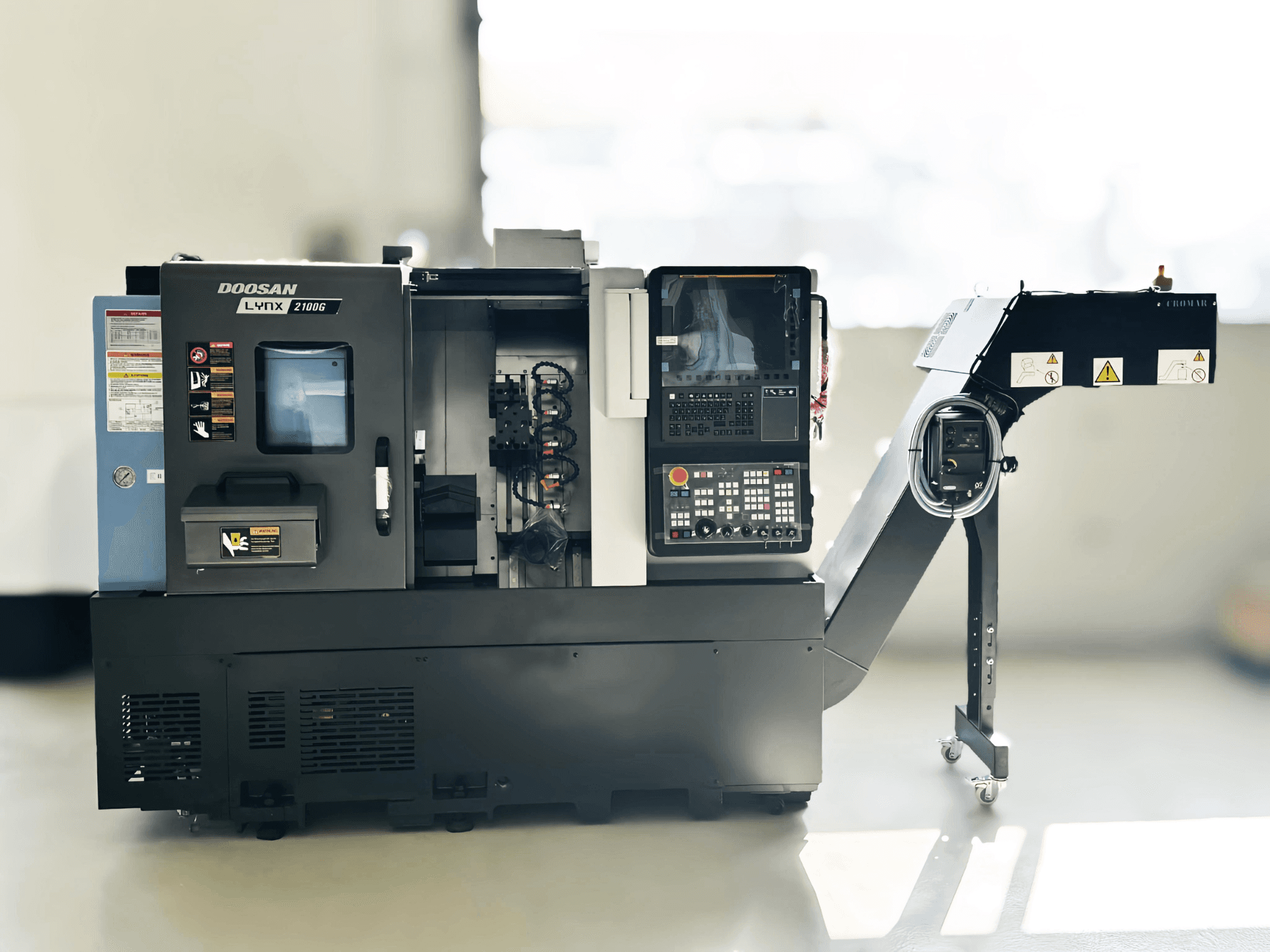 DOOSAN LYNX 2100GA Šveices tipa virpošanas mašīna sānu skatā ar redzamu vadības paneli un instrumentu turētāju.
