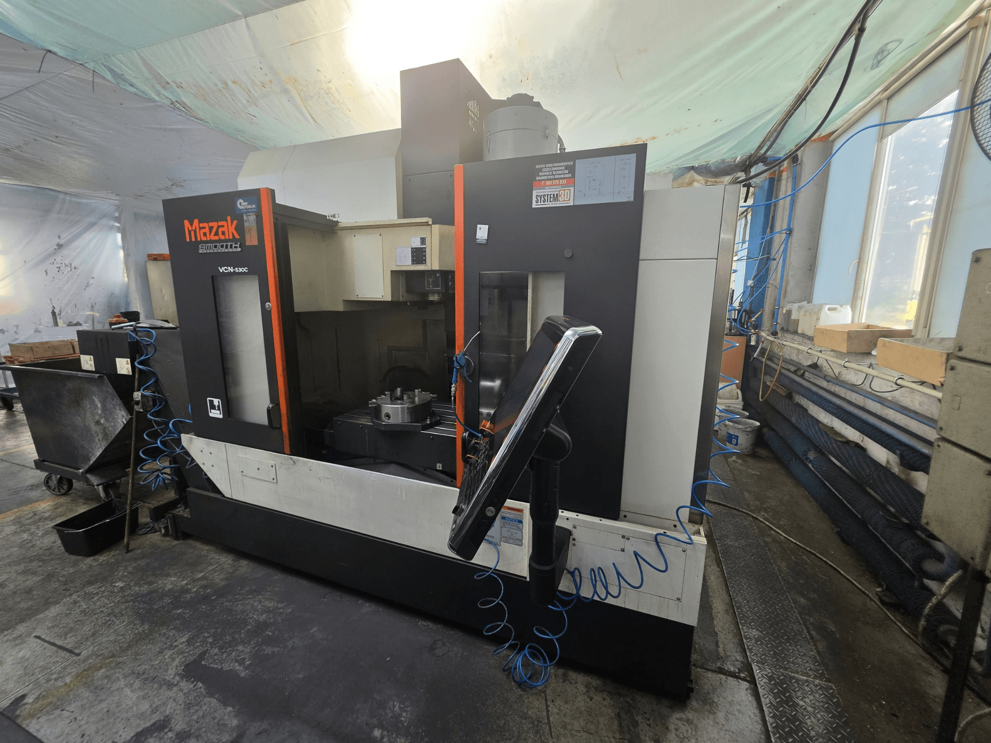 Mazak VCN-530C vertikālais apstrādes centrs, skats no priekšpuses, kurā redzams vadības panelis, darba zona un instrumentu turētājs.