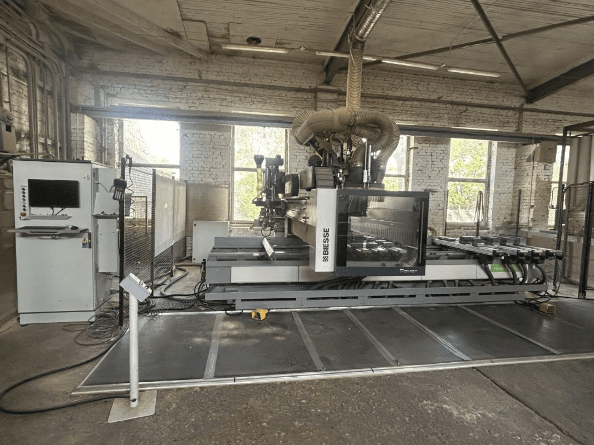 BIESSE Rover A Edge 1643 CNC apstrādes centrs, skats no priekšpuses, kurā redzams vadības panelis, darba galds un rūpnieciskā vide.