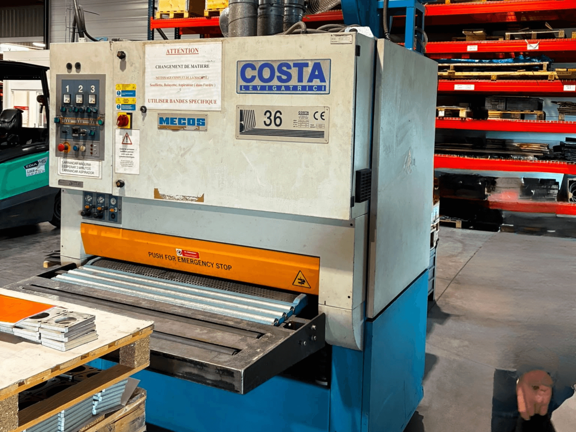 Costa M36 CCS 1150 atgriežu noņemšanas mašīna, skats no sāniem, kurā redzams vadības panelis, avārijas apstādināšanas poga un konveijera virsma.