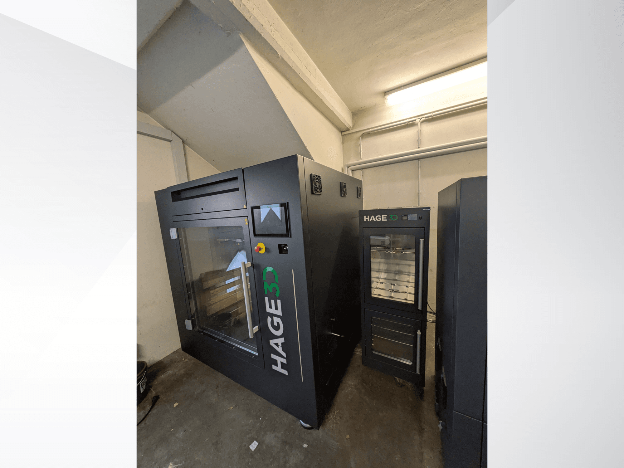 HAGE 3D Precision One plastmasas 3D printeris, skatīts no stūra, ar caurspīdīgām durvīm un vadības paneli, blakus tam atrodas uzglabāšanas vieta.