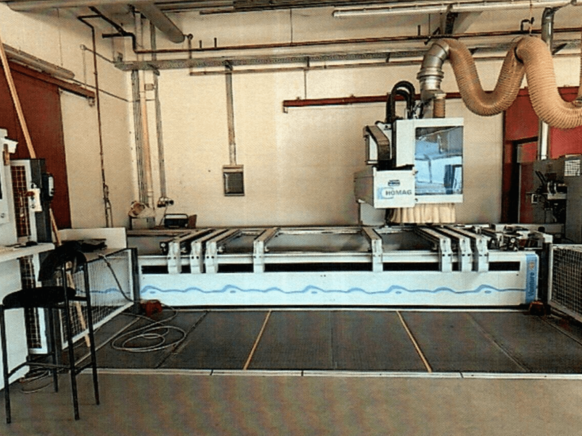 HOMAG BAZ 211/40K CNC kokapstrādes centrs darbnīcā, kurā redzams mašīnas vadības panelis un griešanas zona.