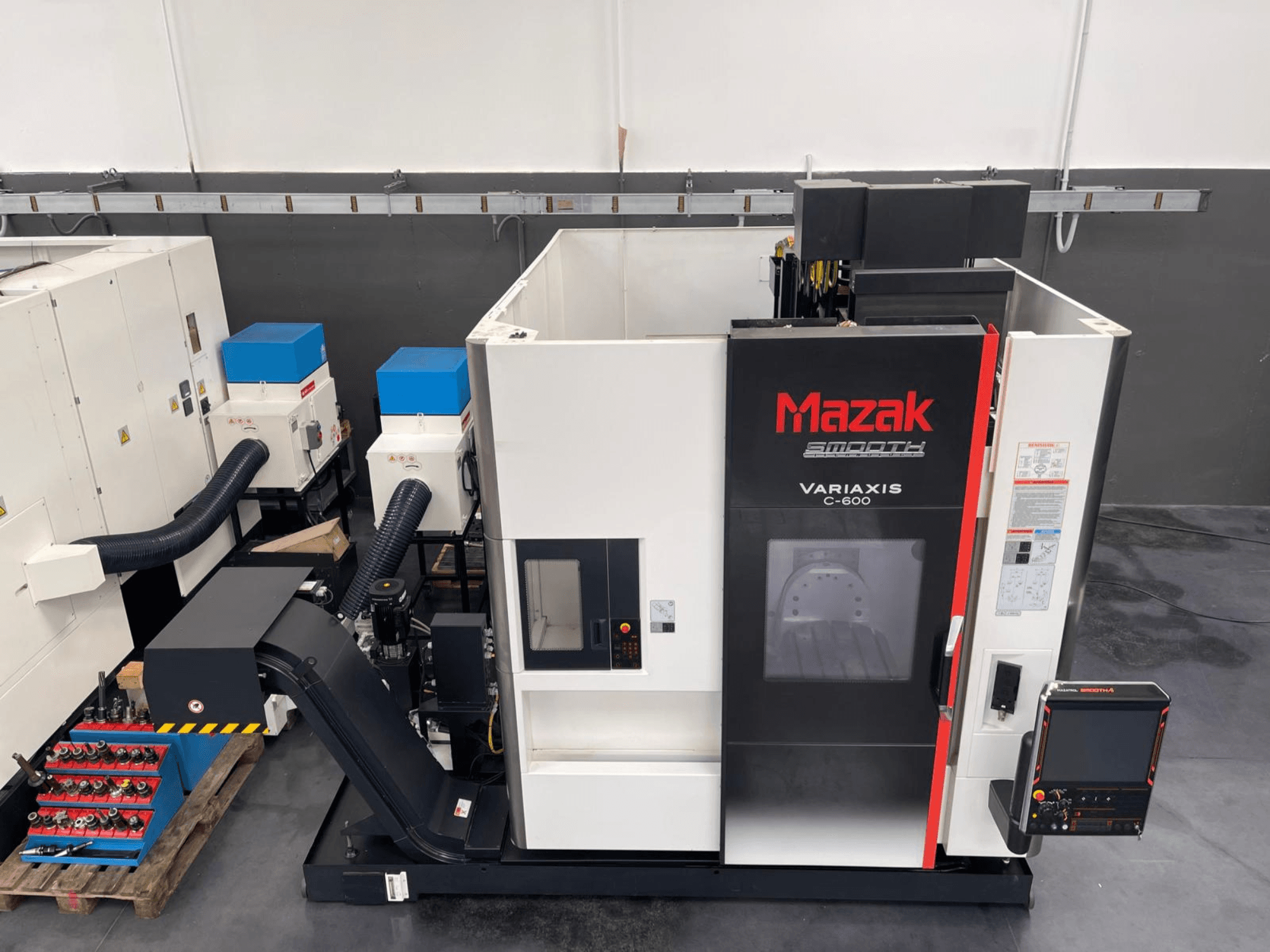 Mazak VARIAXIS C 600 vertikālais apstrādes centrs, priekšējais skats, kurā redzams vadības panelis un instrumentu glabāšanas vieta.