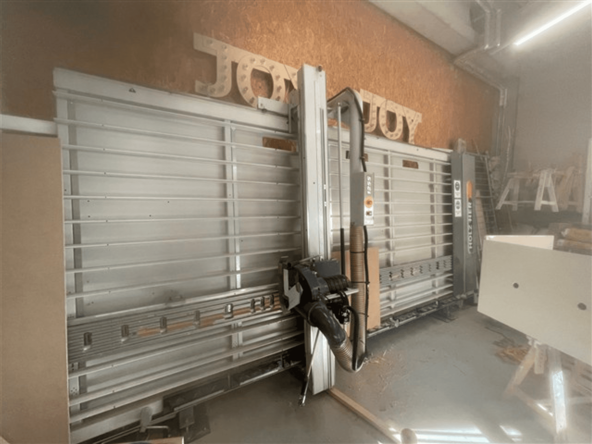 Horizontālais paneļu zāģis, zīmols Holz-Her, skats no sāniem, redzams zāģa asmens, putekļu nosūcējs un glabāšanas vieta.