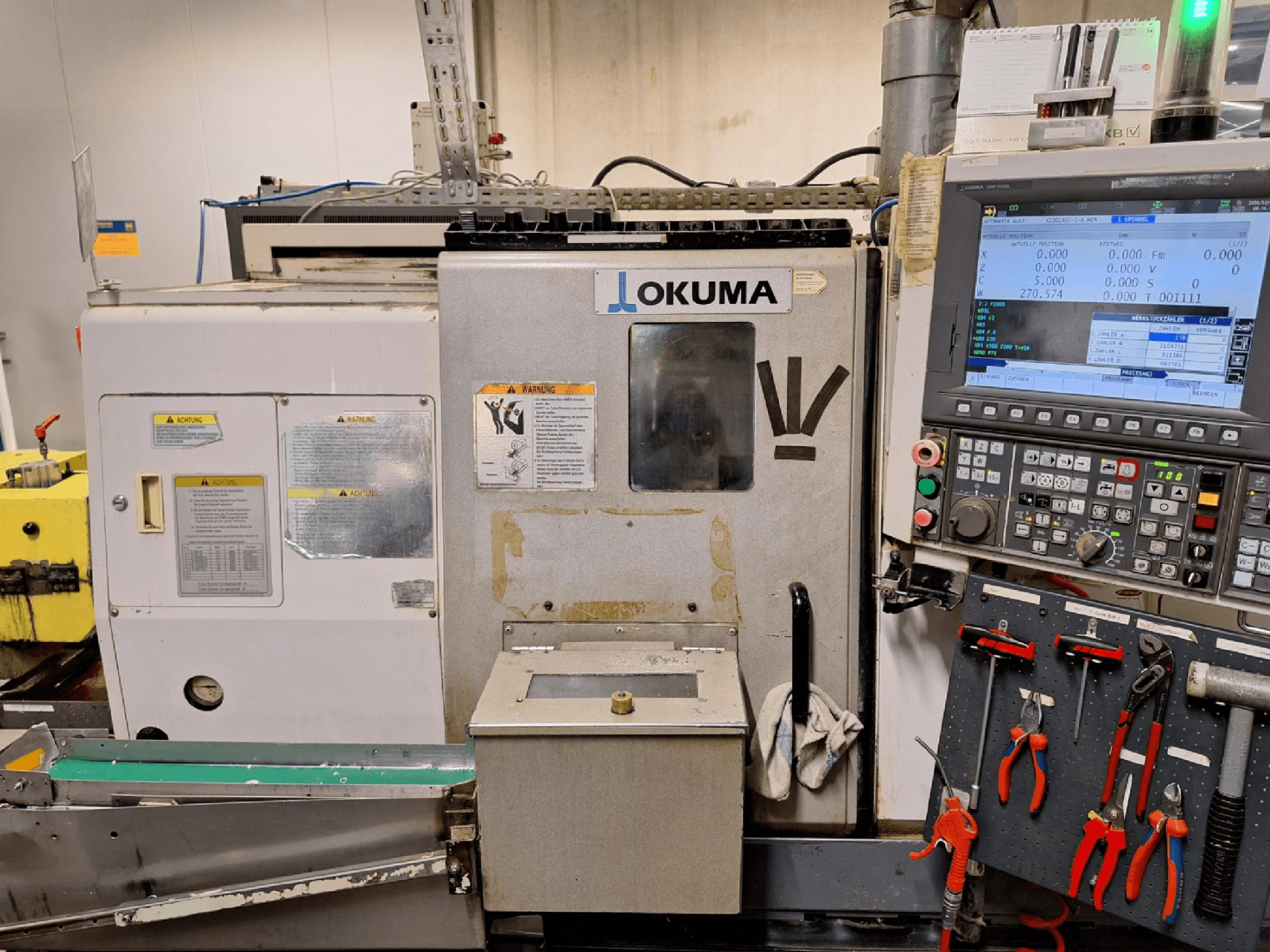 Okuma LB200-MW horizontālā virpošanas mašīna, skats no priekšpuses, ar redzamu vadības paneli un instrumentiem sānos.