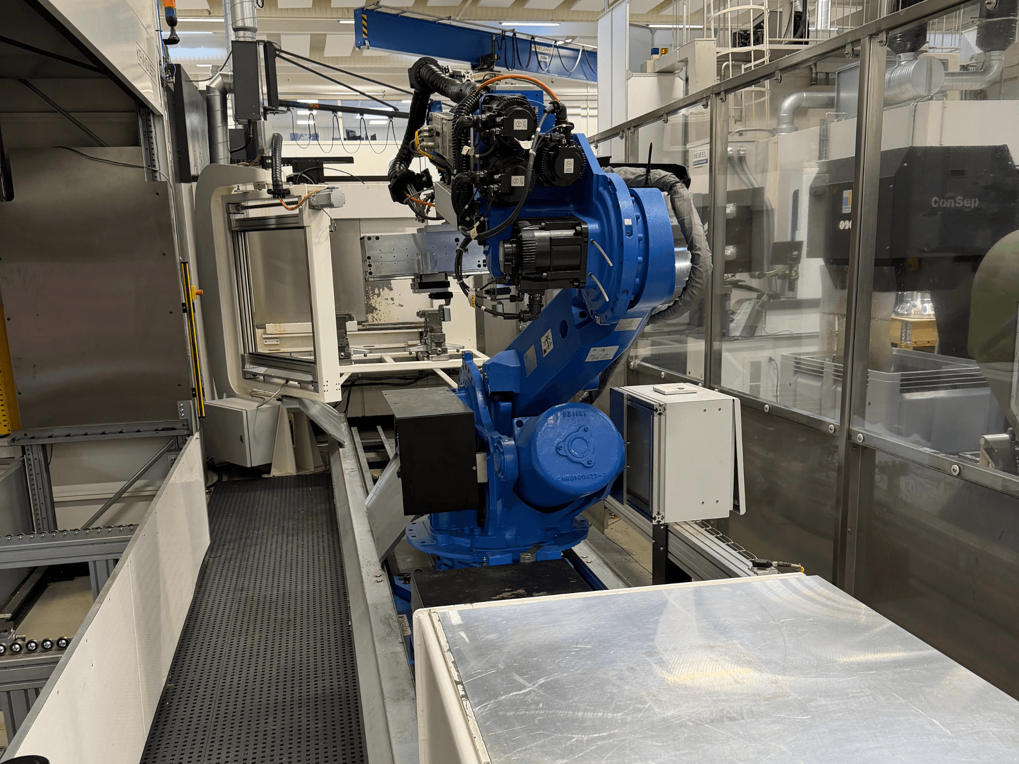 Yaskawa Motoman ES165D robotizētā roka uz sliedes, sānu skats, kurā redzama automatizācijas uzstādīšana rūpnieciskā vidē.