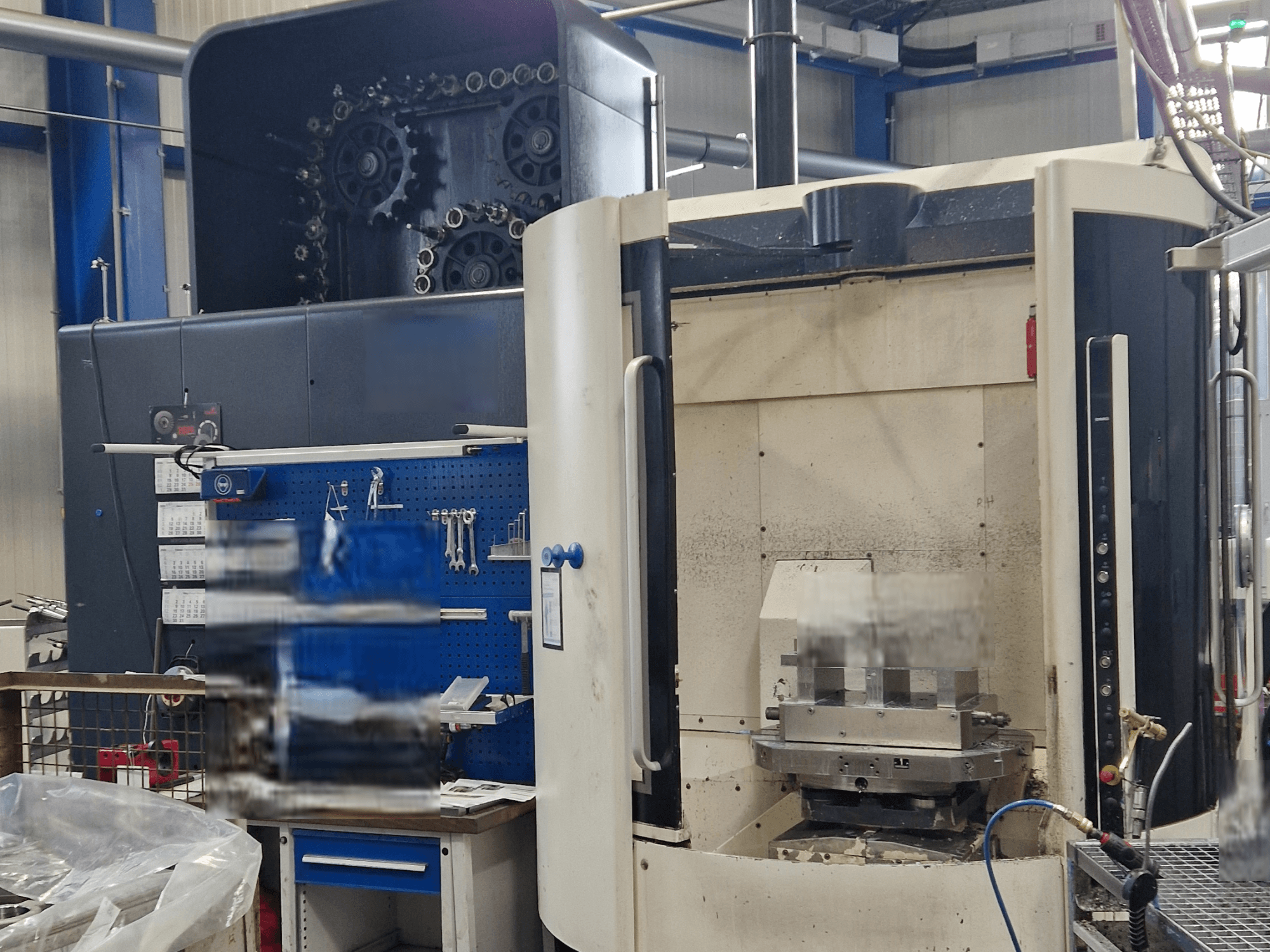 DMG DMC80U DuoBlock universālais apstrādes centrs, priekšējais skats, vadības panelis un darba zona ar instrumentu piederumiem.