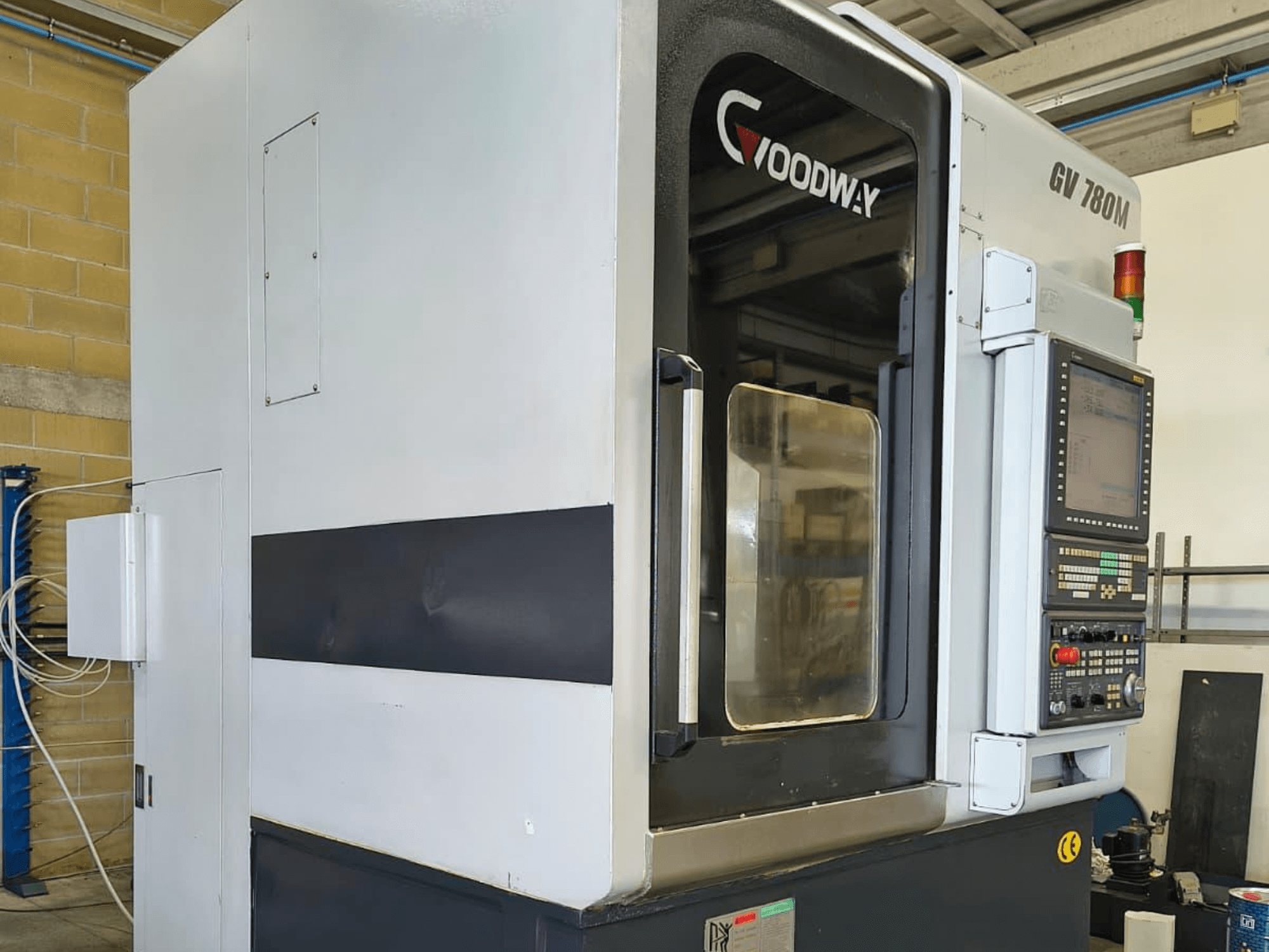 Goodway GV 780 M vertikālās virpošanas mašīna, skats no sāniem, kurā redzams vadības panelis, drošības elementi un tīrs ārējais dizains.