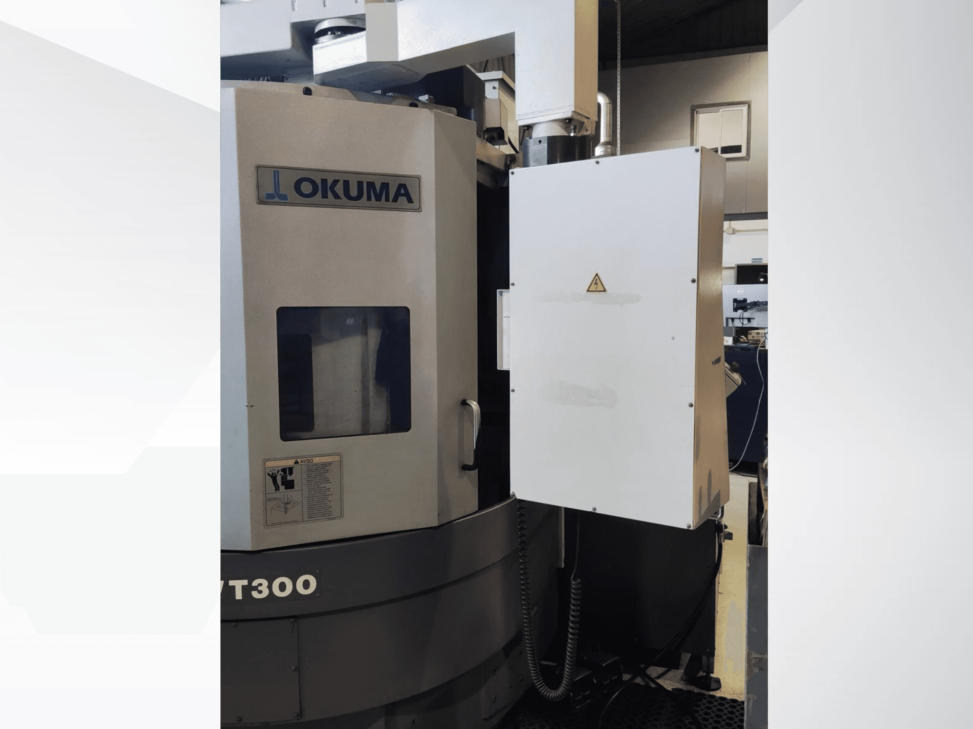 Okuma LVT300 vertikālās virpošanas iekārta, skats no priekšpuses, redzams vadības panelis un marķētas drošības funkcijas.