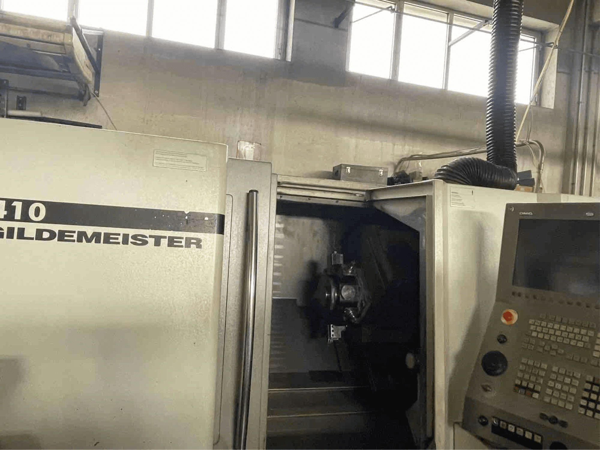 DMG CTX410 horizontālās virpošanas darbgalds, skats no priekšpuses, redzams vadības panelis un iekšpusē redzamie apstrādes komponenti.