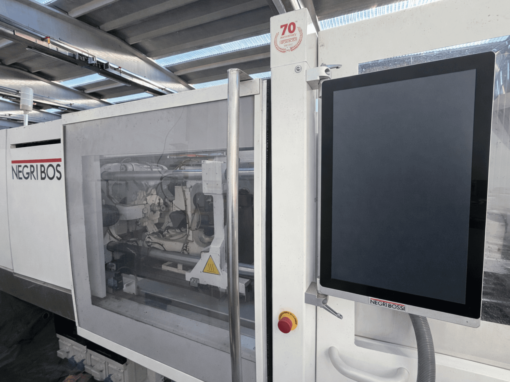 Negri Bossi ELE 80 elektriskā iesmidzināšanas iekārta, priekšējais skats ar vadības ekrānu un redzamām iekšējām detaļām.