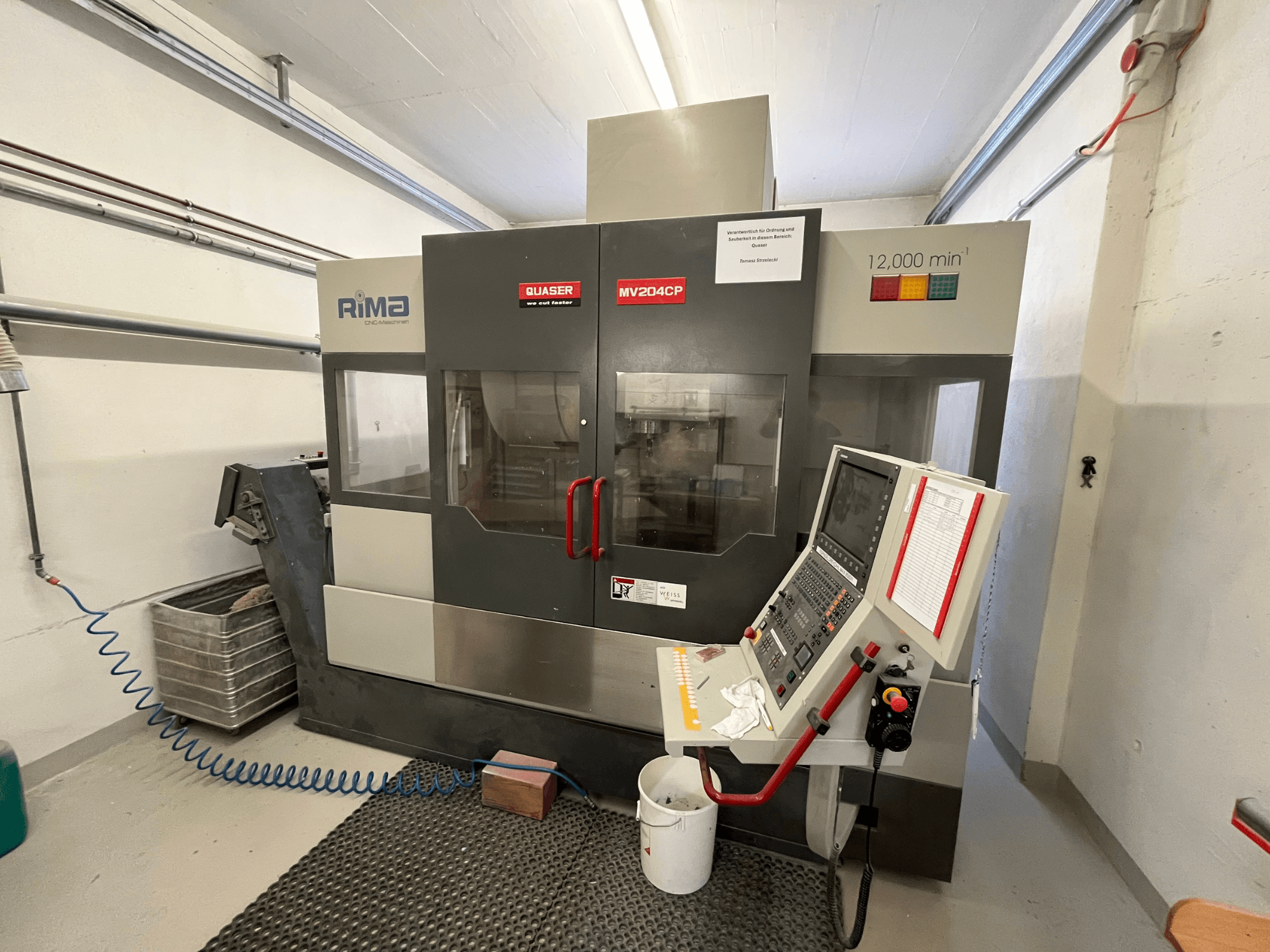 Quaser MV-204 CP vertikālais apstrādes centrs no priekšpuses, ar vadības paneli un darbības detaļām.