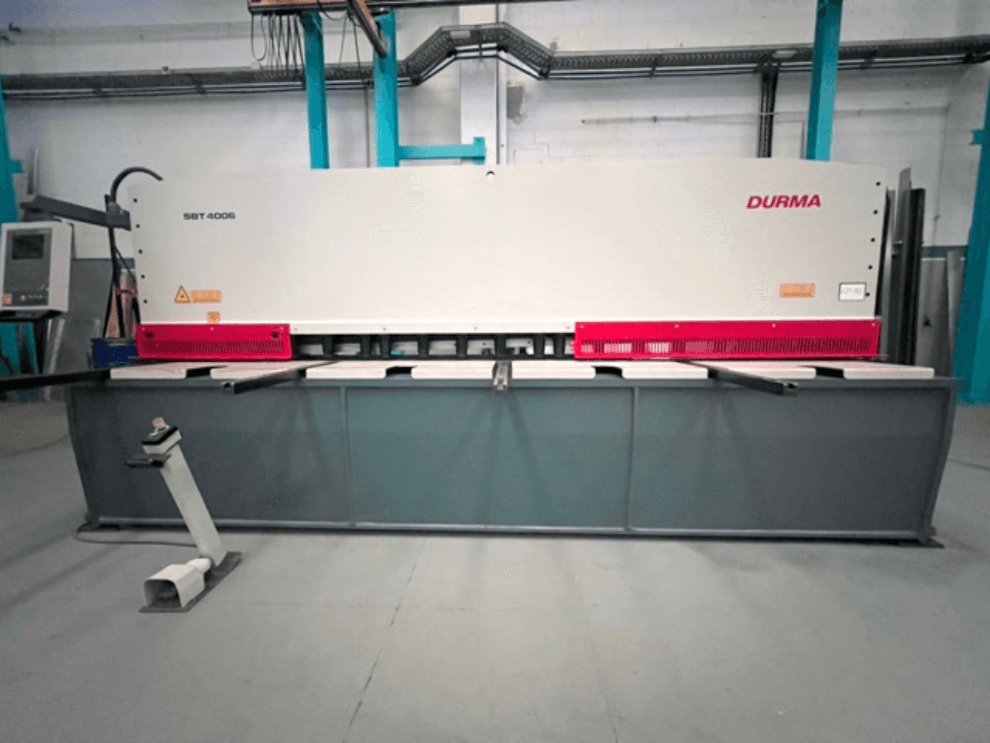 CNC šķēres Durma SBT 4006 no priekšpuses, ar pelēku pamatni un sarkaniem akcentiem, gatavas darbam rūpnīcā.