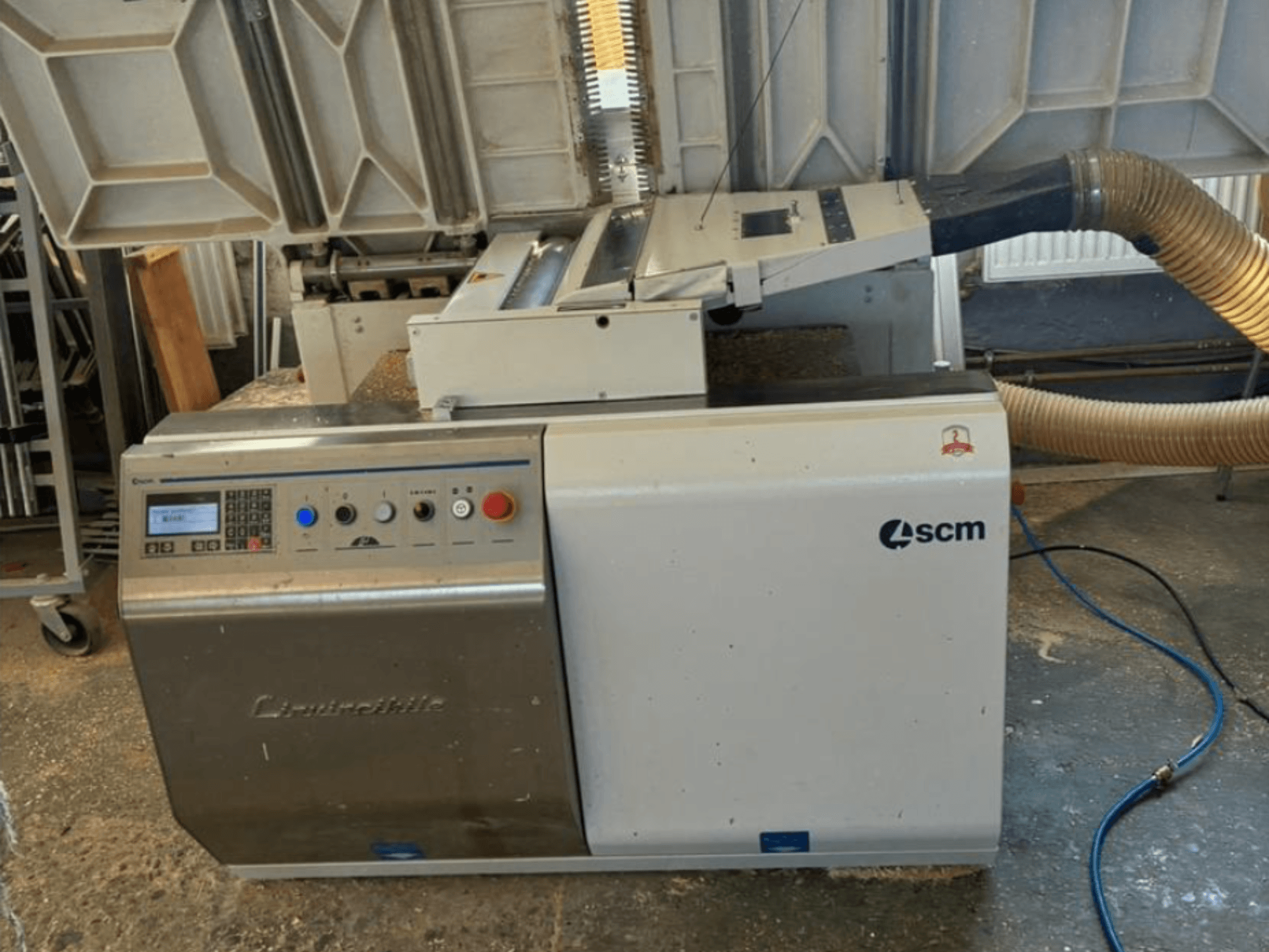 SCM Centauro malu līmēšanas iekārta priekšpusē, kurā redzams vadības panelis, sūknēšanas šļūtene un atvērta darba zona malu līmēšanai.