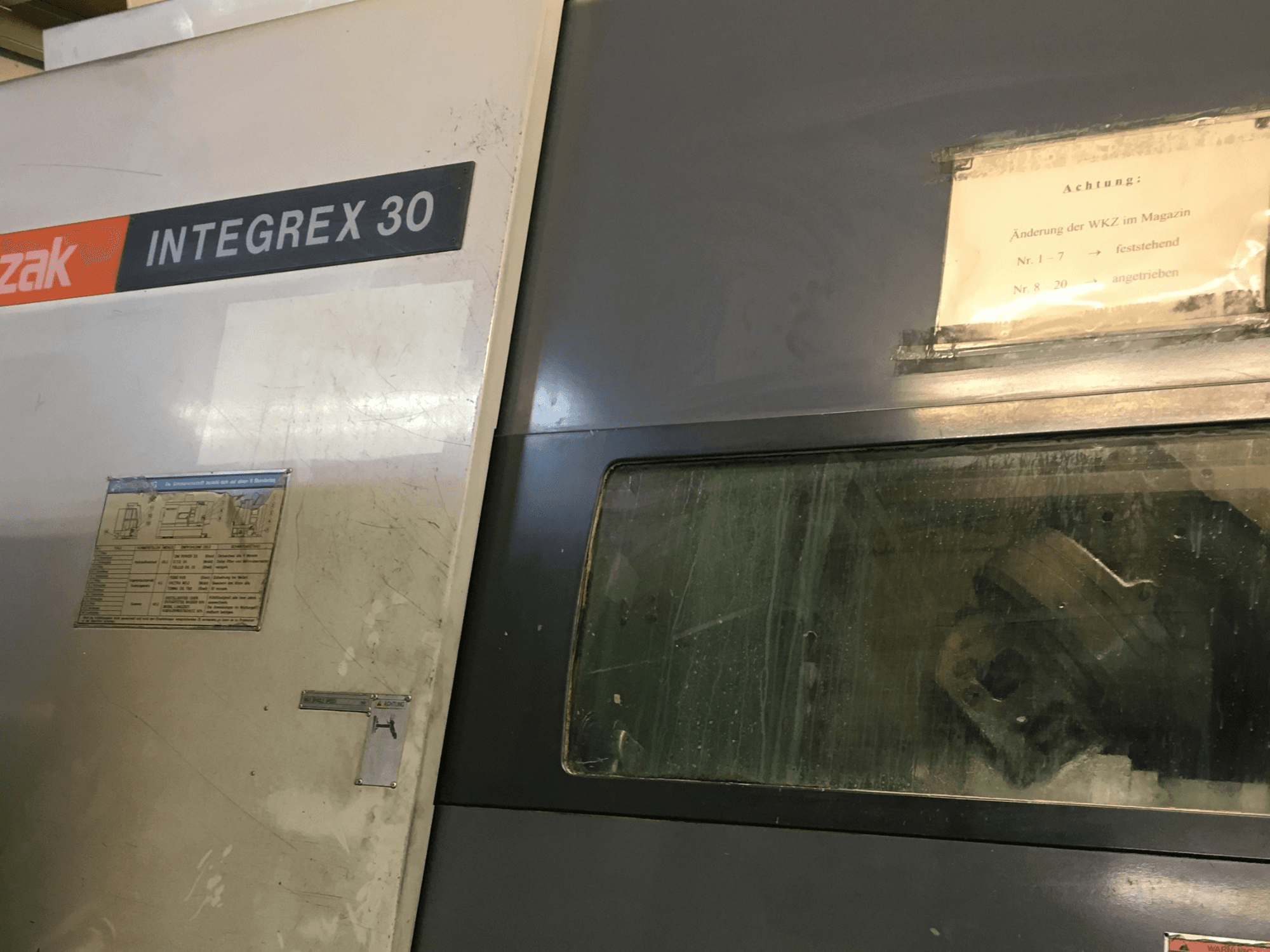 Mazak Integrex 30 Y Universal 1000 virpošanas-frēzēšanas centra skats no priekšpuses, kurā redzamas vadības ierīces un caur logu redzami darba rīki.
