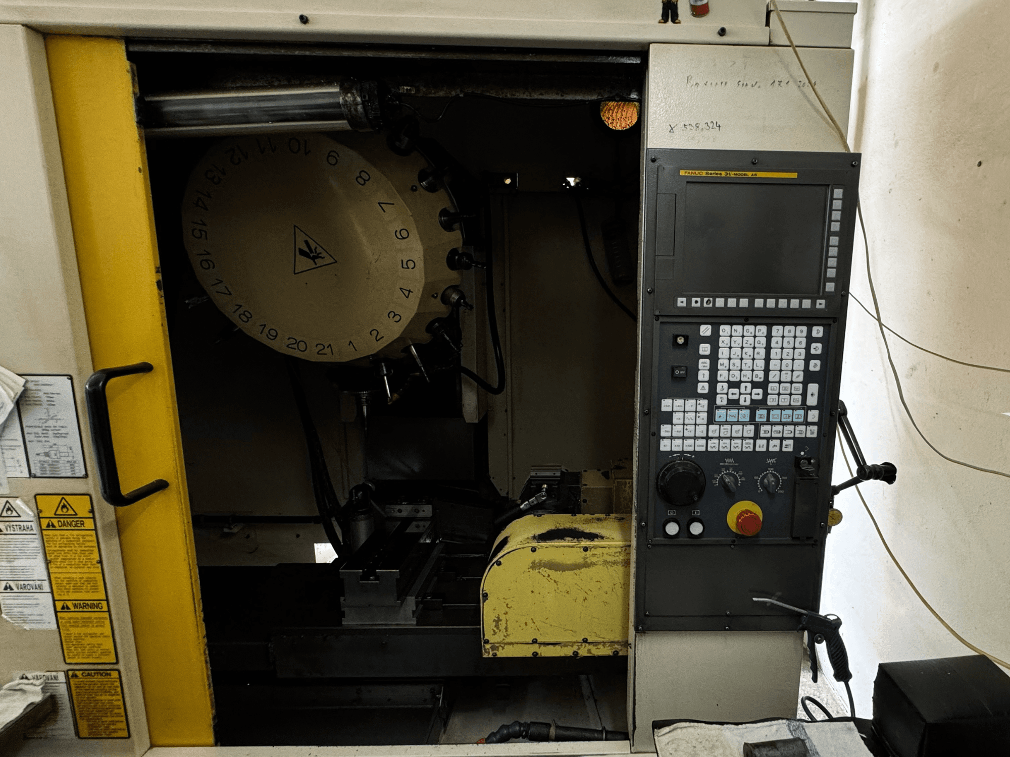 FANUC Robodrill alpha-T21iFL vertikālais apstrādes centrs, priekšējais skats, kurā redzams vadības panelis un instrumentu magazīns.