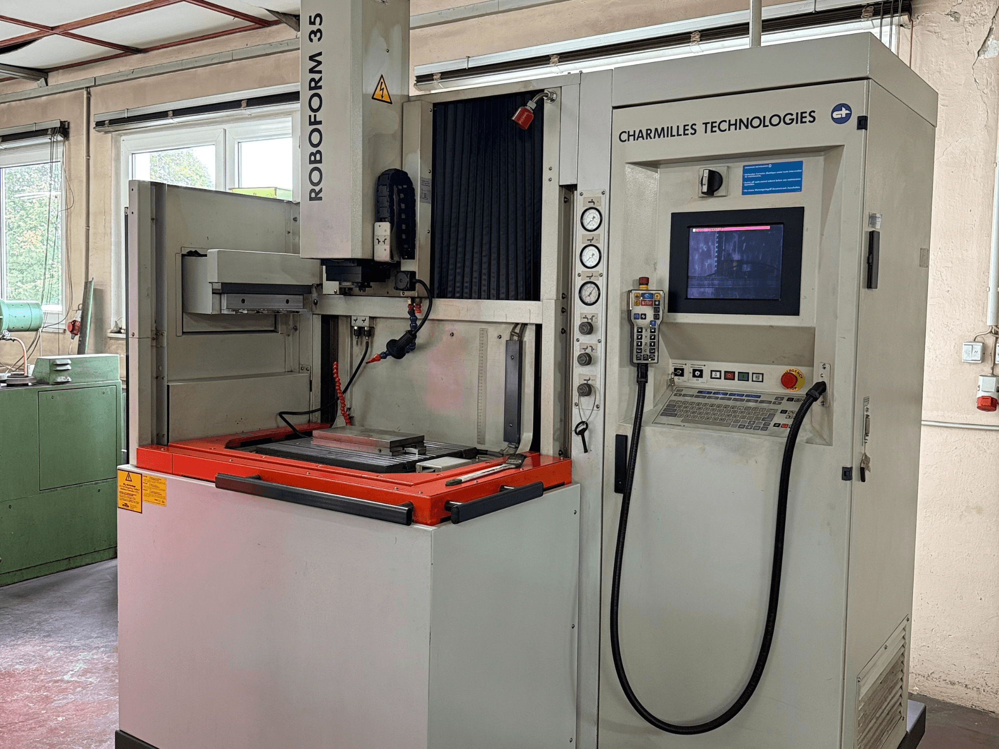 Charmilles Technologies Roboforn 35 mašīna, priekšējais skats, kurā redzams vadības panelis, uzstādītie instrumenti un drošības marķējums.