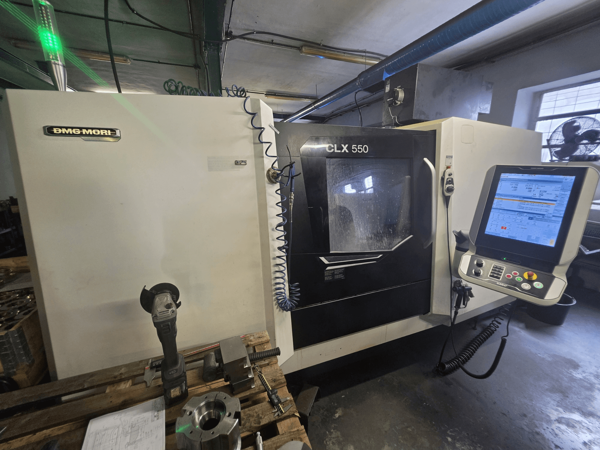 DMG MORI CLX 550 V3 horizontālā virpošanas mašīna, skats no priekšpuses, kurā redzams vadības panelis, griešanas instrumenti un mašīnas korpuss.