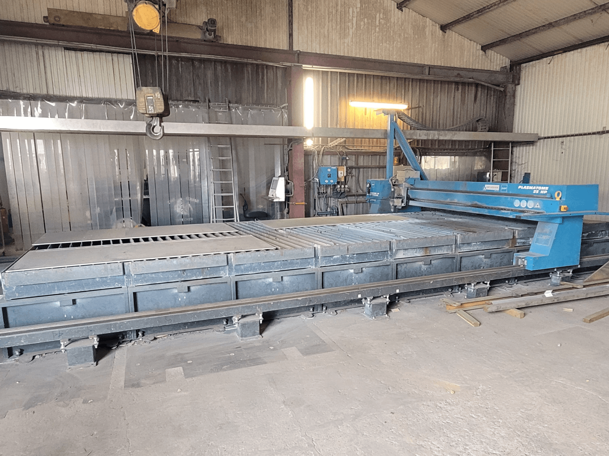 SAF Plasmatone 25Hp plazmas griešanas iekārta, skats no sāniem, kurā redzama griešanas gulta un darbības komponenti rūpnieciskā vidē.