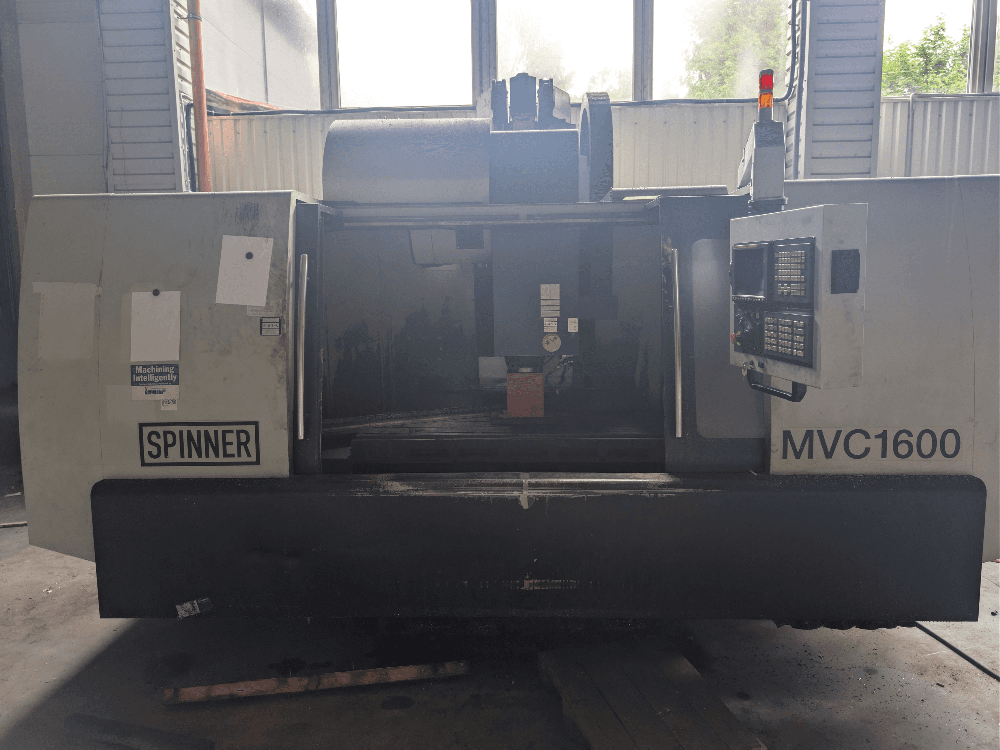 Vertikālais apstrādes centrs SPINNER MVC-1600, skats no priekšpuses, kurā redzams vadības panelis un apstrādes zona. Piemērots precīzai apstrādei.