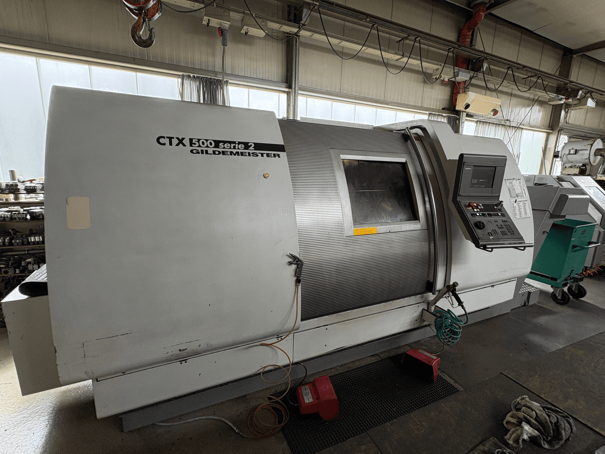Horizontālā virpošanas mašīna „Gildemeister CTX 500 S2“, skats no sāniem, kurā redzams vadības panelis un galvenā korpusa detaļas.