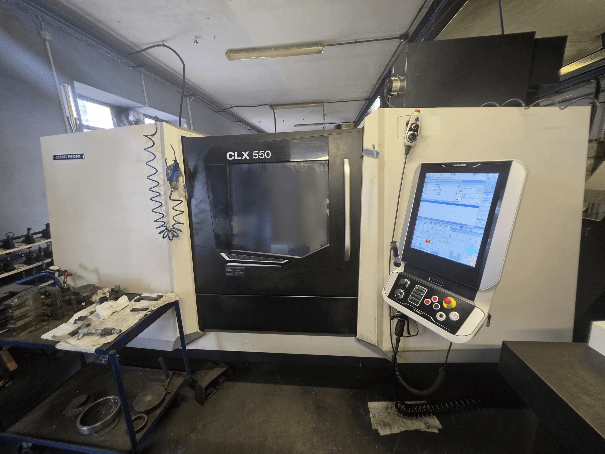 DMG MORI CLX 550 V3 horizontālā virpošanas mašīna, skats no priekšpuses, kurā redzams vadības panelis un darba zona ar instrumentiem.