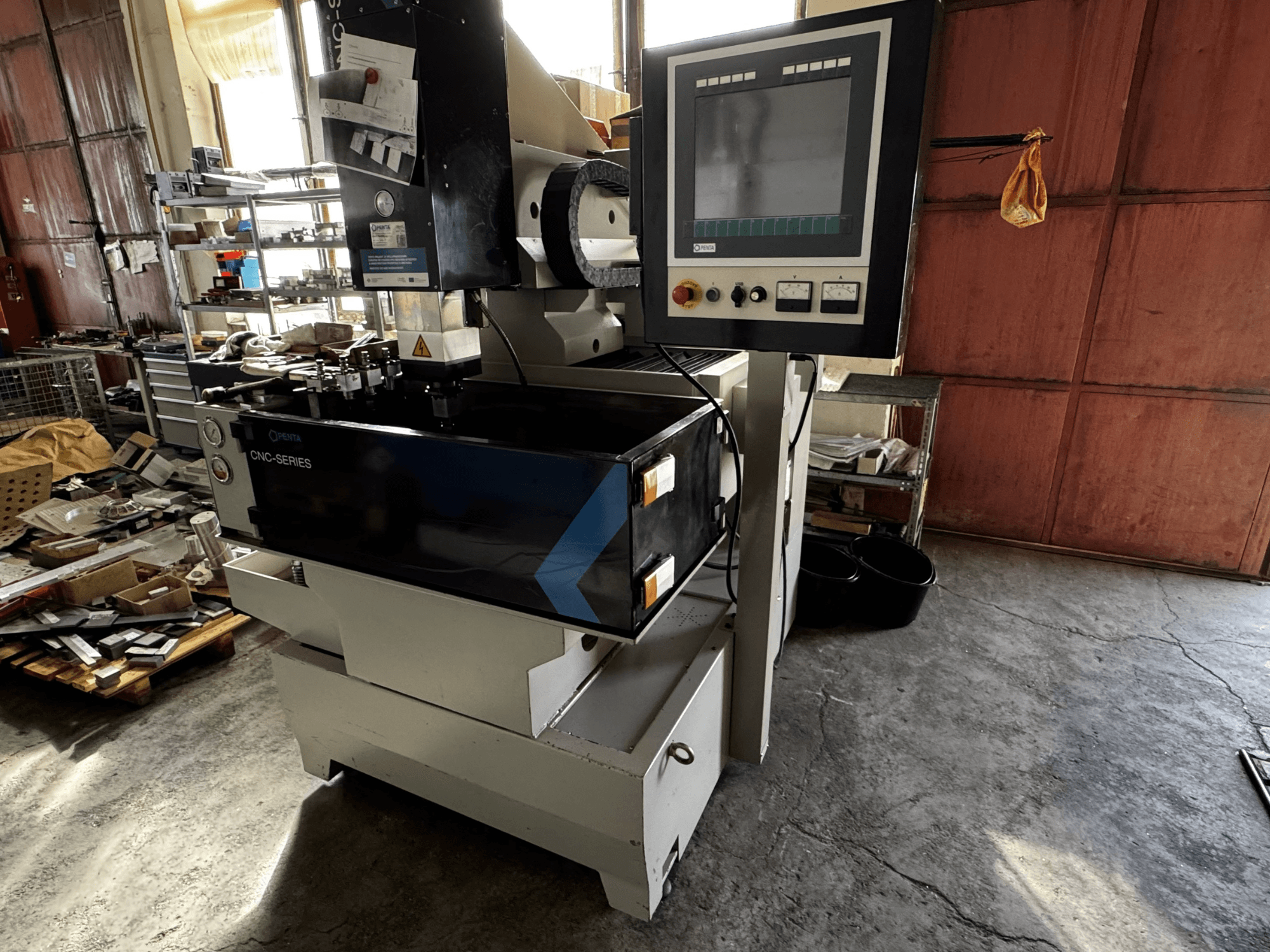 PENTA 433GS CNC štancēšanas EDM mašīna, skats no priekšpuses. Displejs, vadības panelis, elektrodu turētājs un metāla darba galds.