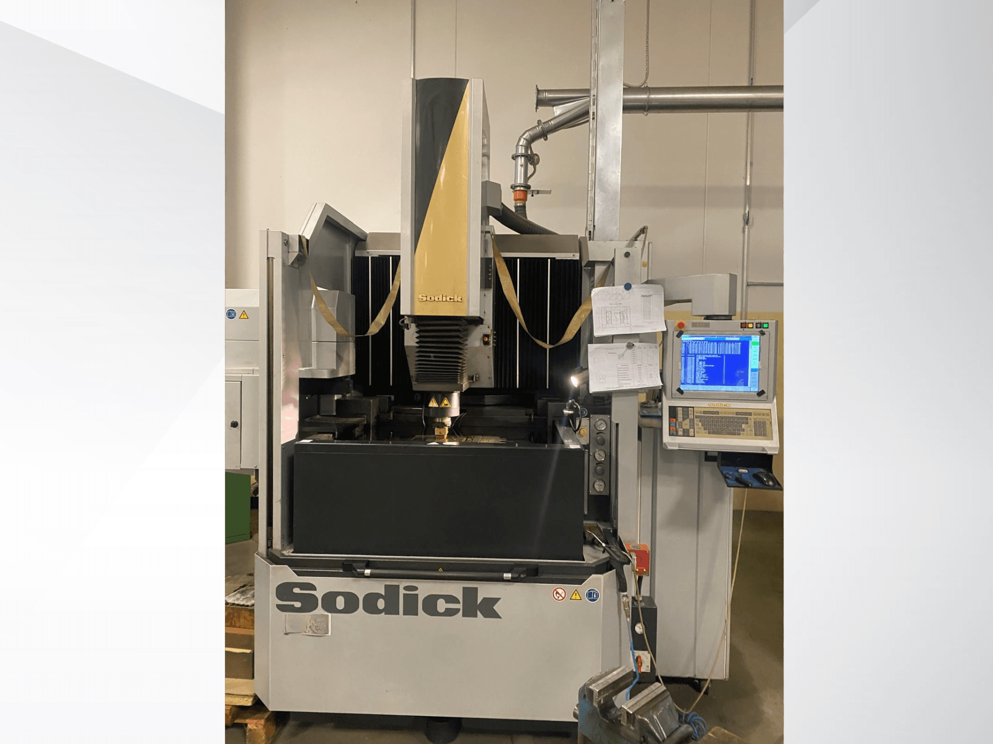 Sodick EDM mašīna priekšpusē ar vadības paneli, darba galdu un augšējo griešanas galvu.