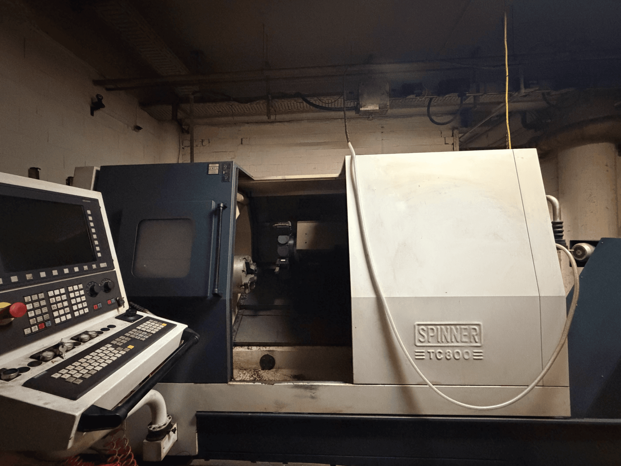 Horizontālās virpošanas iekārta SPINNER TC800, priekšējais skats ar redzamu vadības paneli un nedaudz atklātu iekārtas iekšpusi.