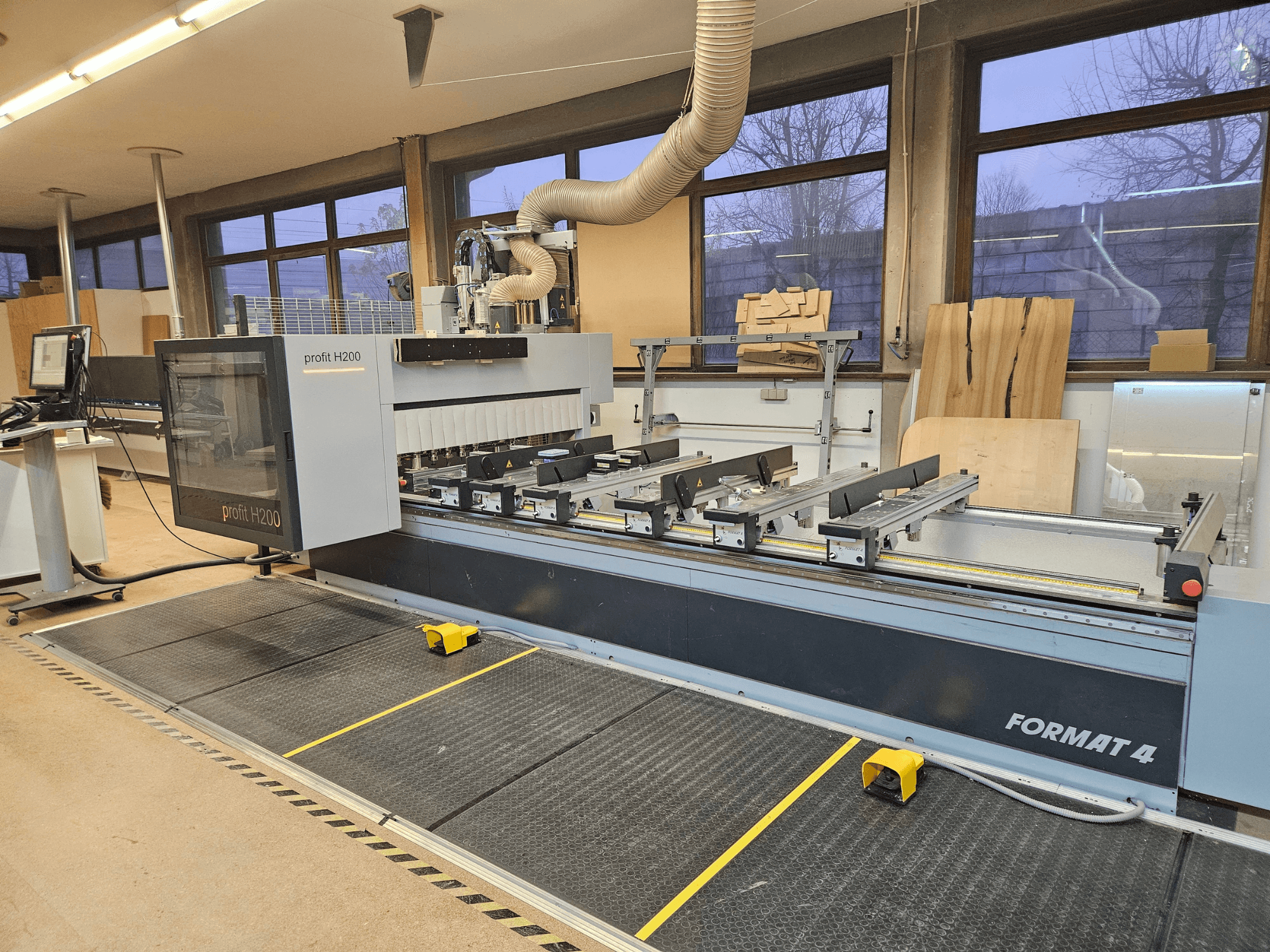 4. formāta peļņas H200 CNC mašīna, skats no priekšpuses, redzama griešanas gulta, vadības panelis un putekļu nosūces sistēma.