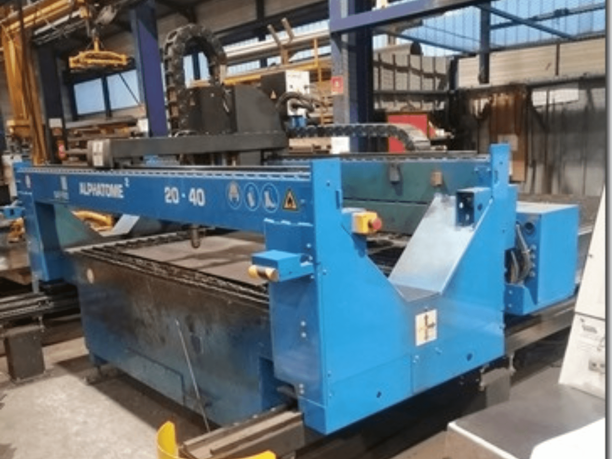 Zilas ALPHATOME 20-40 CNC darbgalds, skats no priekšpuses, ar redzamu griešanas zonu un vadības paneli, paredzēts precīzai ražošanai.