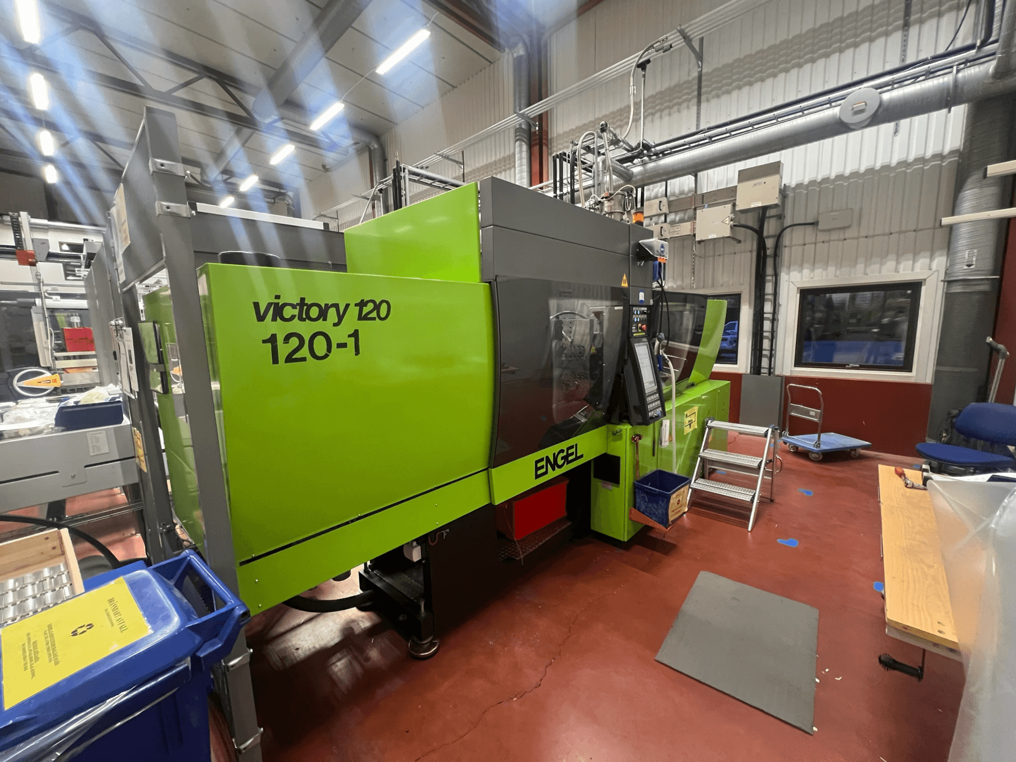 Zaļa ENGEL Victory 120-1 injekcijas formēšanas iekārta, priekšējais skats, ar vadības paneli un pakāpieniem, rūpnieciskā vidē.