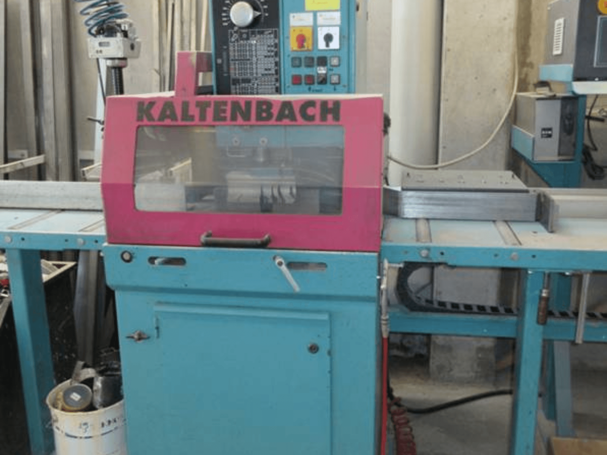 KALTENBACH KKS 400 E ripzāģis metālam priekšpusē, ar rozā drošības vāku un vadības paneli ar pogām.