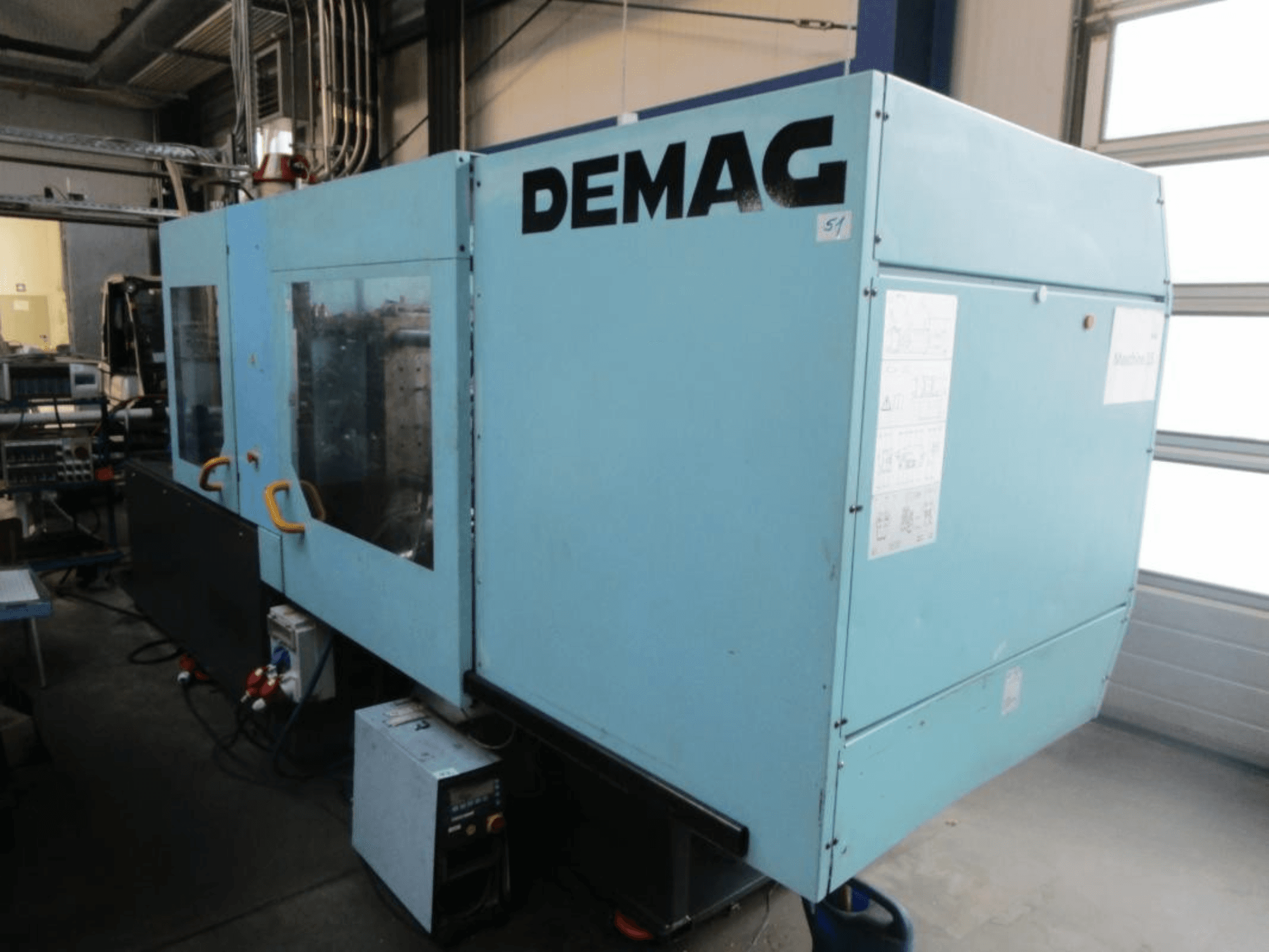 DEMAG Ergotech 150-610 Viva hidrauliskās plastmasas liešanas mašīnas skats no priekšpuses, kurā redzams vadības panelis un rokturi.