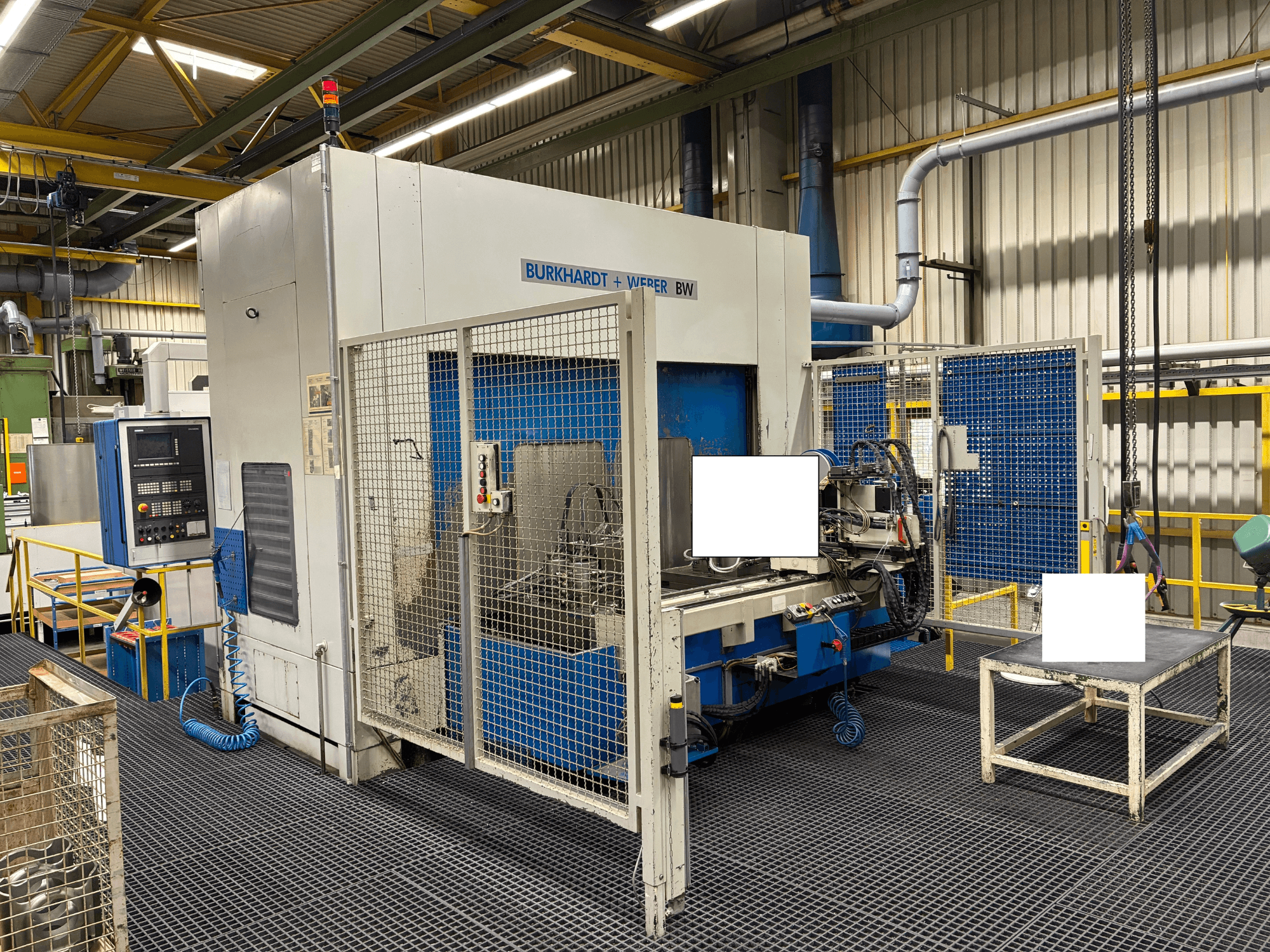 Burkhardt + Weber BW apstrādes centrs, skats no priekšpuses, aprīkots ar vadības paneli un drošības nodalījumu, atrodas rūpnieciskā vidē.