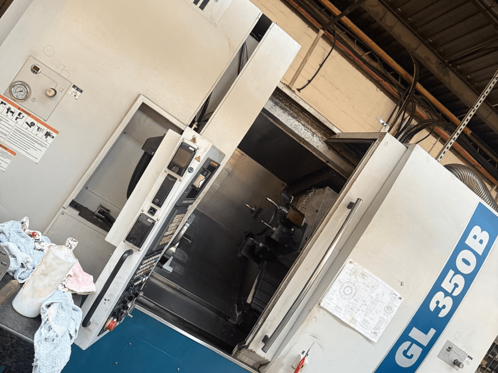 Horizontālās virpošanas iekārta Romi GL 350B, skats no priekšpuses, ar vadības paneli un atvērtām durvīm, kas atklāj iekšpusi.