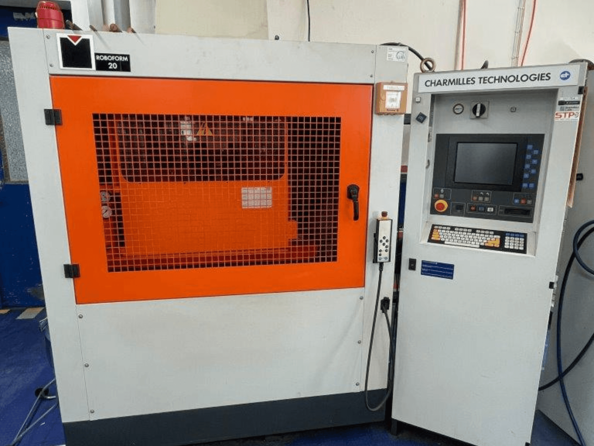 AgieCharmilles Robofrom 20 presformas iegremdēšanas EDM mašīna, priekšējais skats ar vadības paneli un oranžo aizsargrežģi.