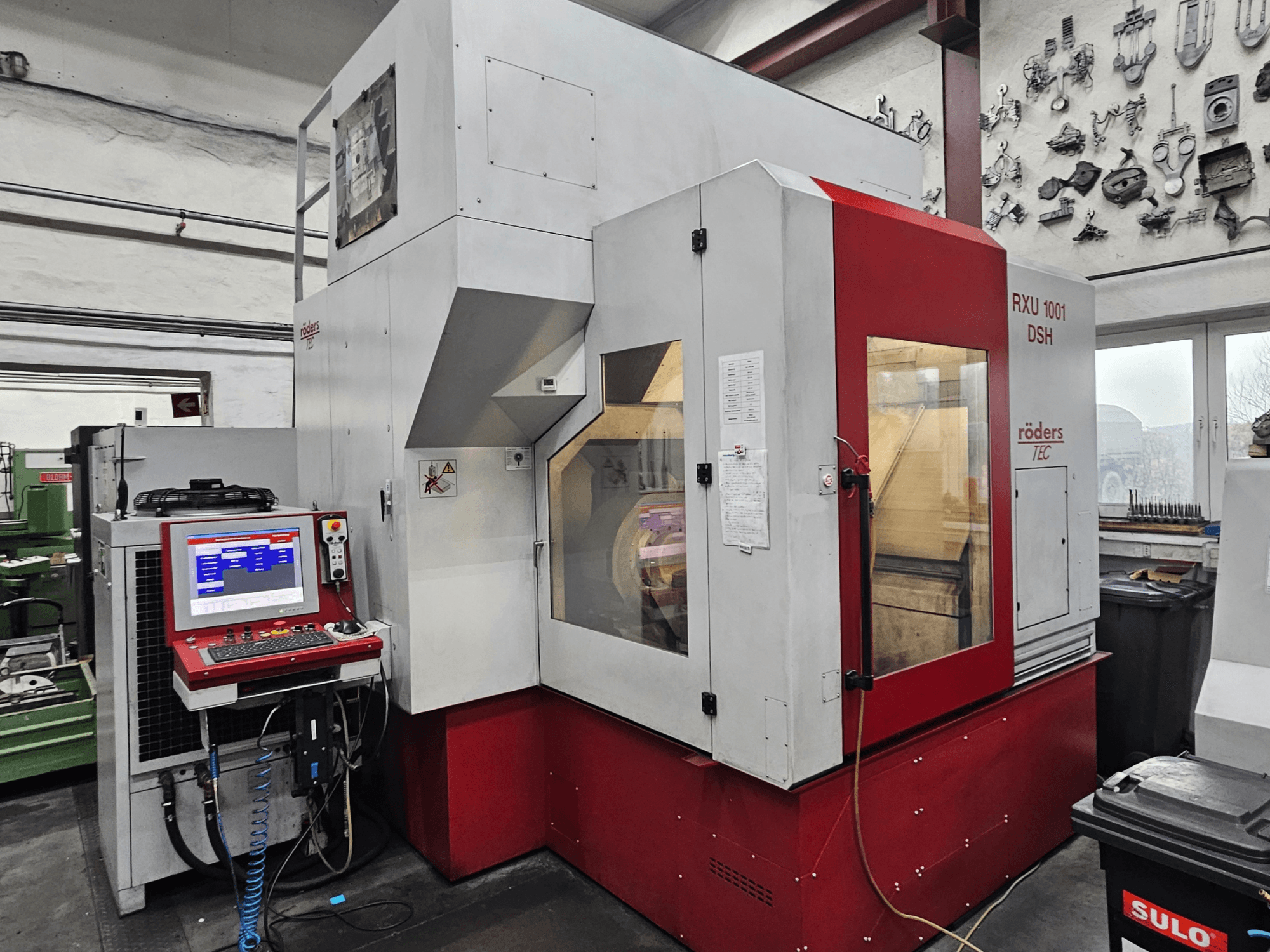 RÖDERS RXU 1001 DSH vertikālais apstrādes centrs, priekšējais skats, kurā redzams vadības panelis un mašīnas detaļas darbnīcā.