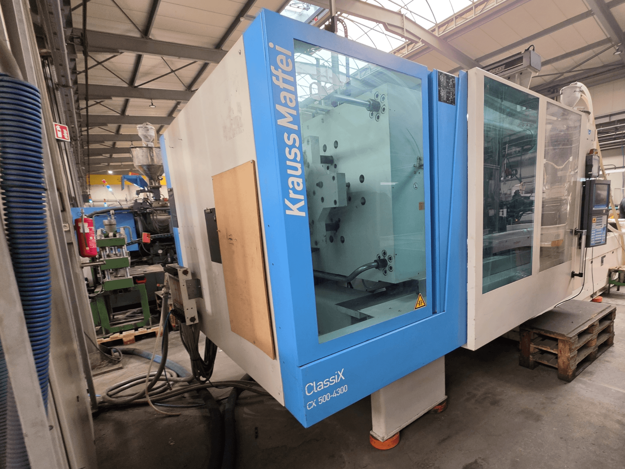 Krauss Maffei 500-4300 CX hidrauliskā iesmidzināšanas iekārta, skats no sāniem, redzams vadības panelis un darbības komponenti.
