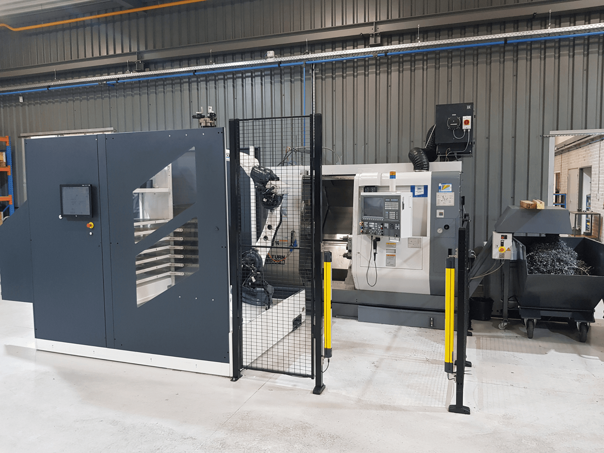 ALTURN automātiskās virpas un CNC darbgalds rūpnīcā; priekšējais skats ar redzamu vadības paneli un drošības žogu.