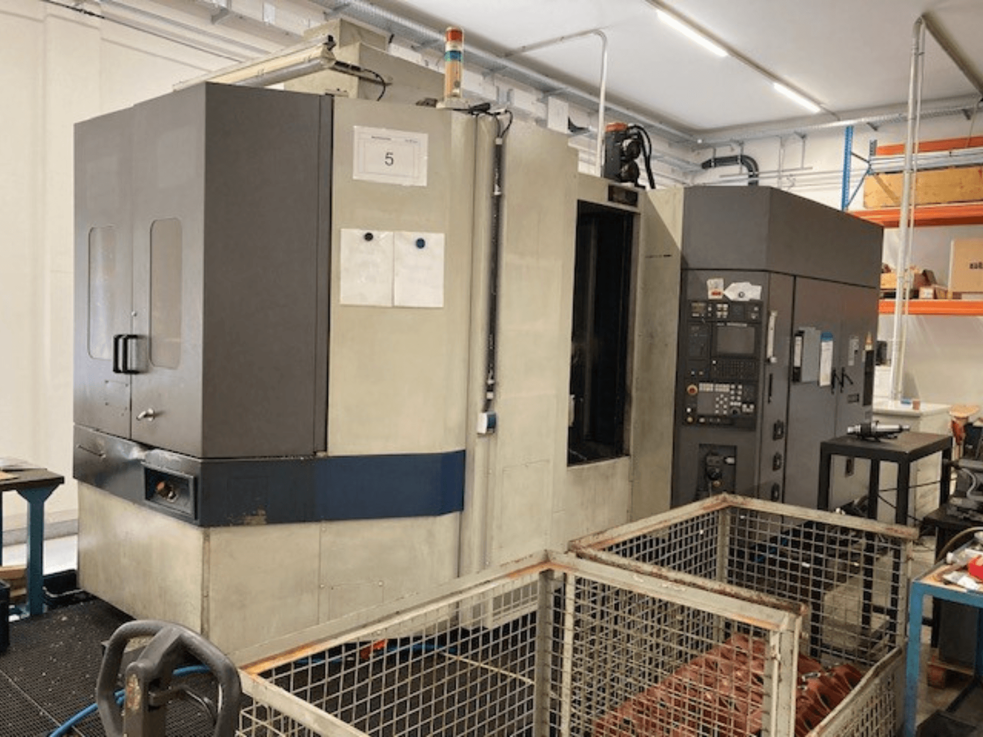 MORI SEIKI SH633 horizontālais apstrādes centrs, skats no priekšpuses, kurā redzams vadības panelis un drošības funkcijas.
