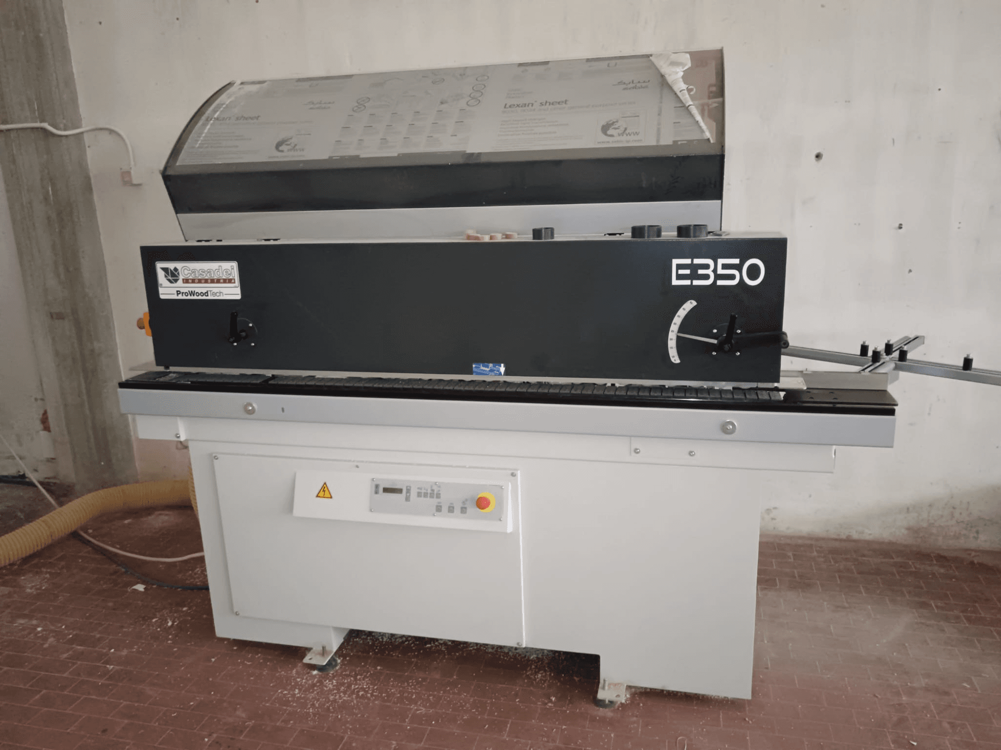 Cesaroli ProWoodtech E350, kokapstrādes mašīnas sānu skats ar vadības paneli un putekļu uzkrāšanu, uzstādīta uz baltas pamatnes.