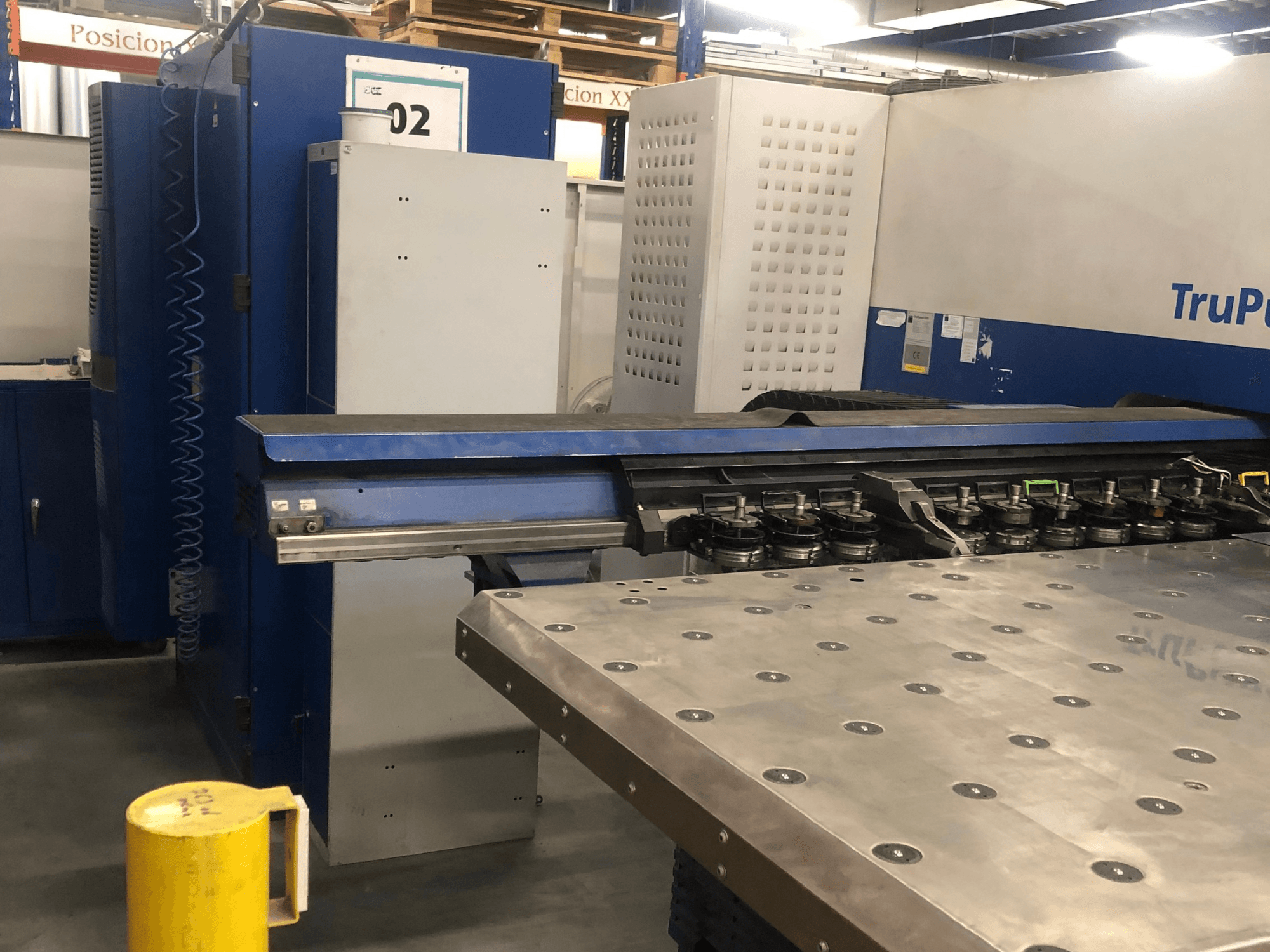 TRUMPF TruPunch 5000 CNC perforācijas mašīna, skats no priekšpuses, kurā redzams instrumentu revolveris un vadības panelis, blakus atrodas metāla darba galds.
