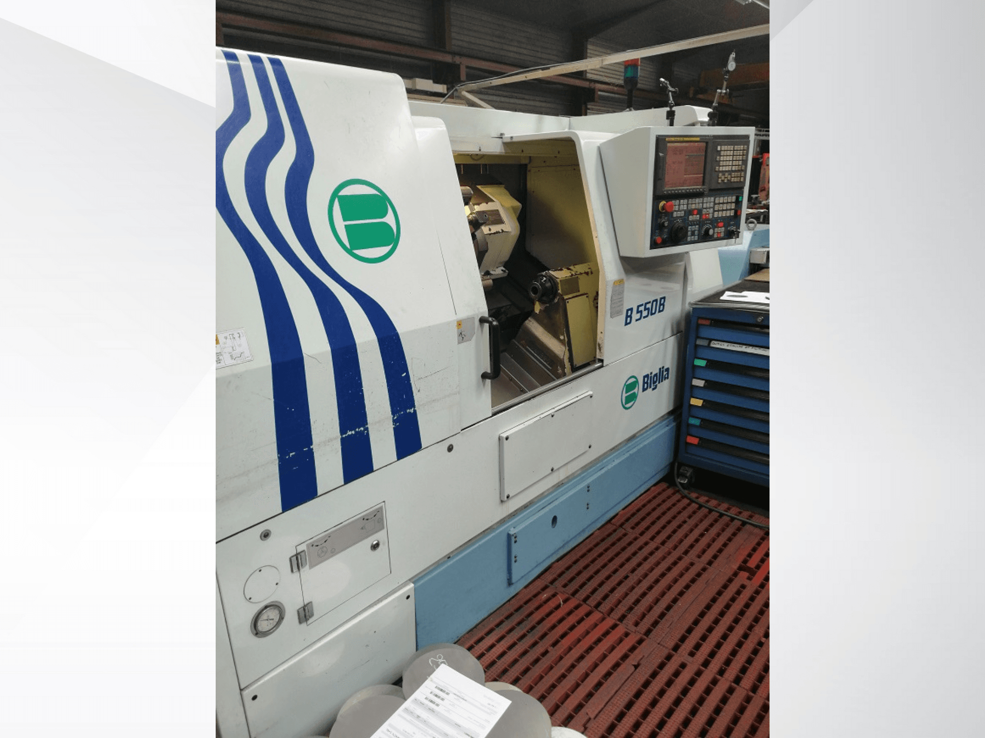 Biglia B 550 B CNC virpa no priekšpuses, ar vadības paneli, metālapstrādes zonu un krāsainu instrumentu uzglabāšanas vietu.